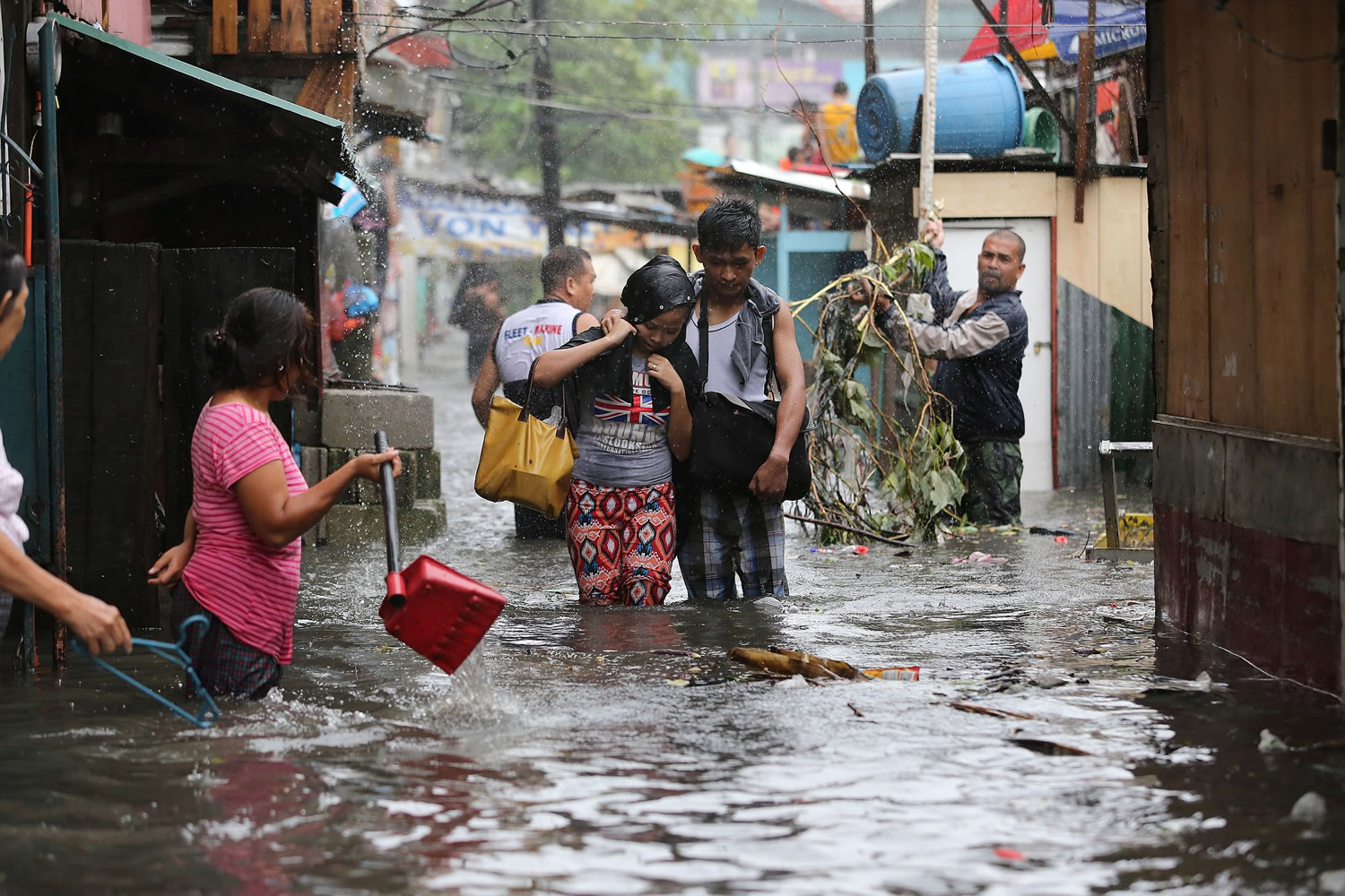 Residents wade through floods as they go back to their home while Typhoon Rammasun batters suburban Quezon city, north of Manila,  Philippines on Wednesday.