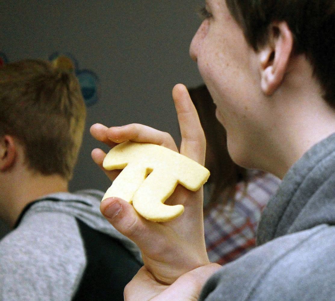 Park High School student David Noble holds a Pi shaped cookie after receiving it from teacher Shari Kepner for correctly answering a question about the mathematical constant, in Livingston, Mont., Thursday afternoon, March 12, 2015. Saturday is the day when love of math and a hankering for pastry come full circle. Saturday is Pi Day, a once-in-a-year calendar date that this time squares the fun with a once-in-a-century twist. Saturday is 3-14-15, the first five digits of the mathematical constant pi: 3.141592653. The best times to celebrate are at 9:26 and 53 seconds, morning and evening. The next time that happens is in March 2115.