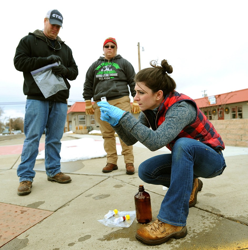 Environmental Protection Agency contractor Megan Adamczyk checks a water sample Wednesday in Glendive, Mont., as water is drained from fire hydrants.