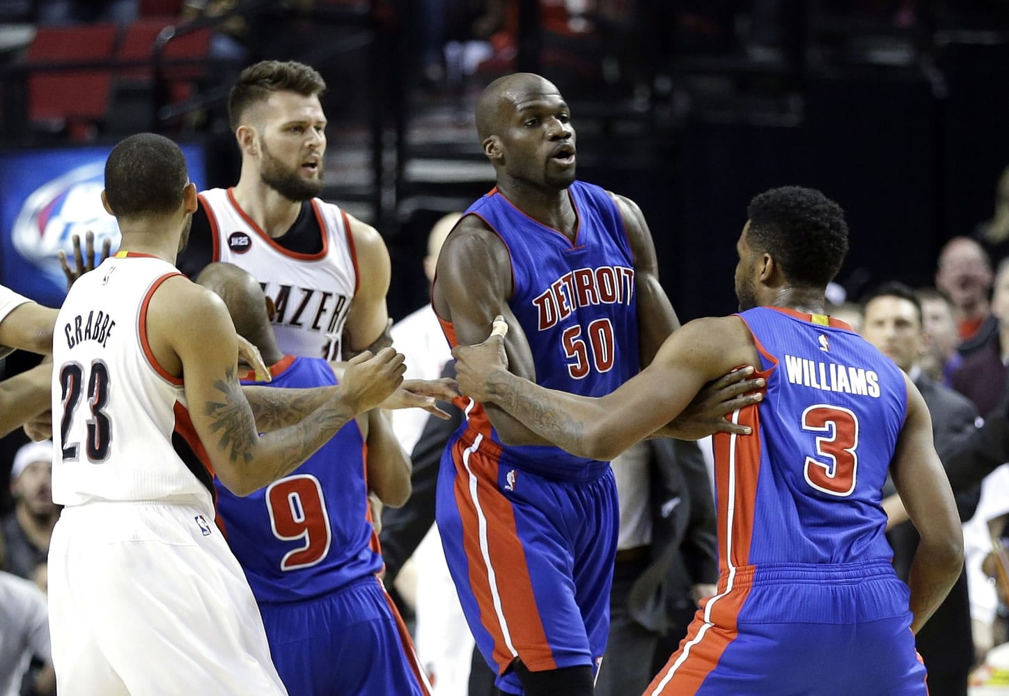 Detroit Pistons forward Shawne Williams, right, is held back by teammate Joel Anthony after an altercation with Portland Trail Blazers forward Joel Freeland, second from left, on Friday.