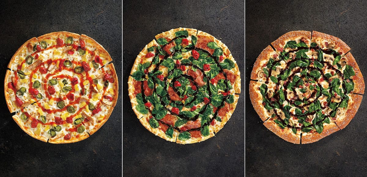 Pizza Hut's new specialty pizzas, from left, Sweet Sriracha Dynamite, Cherry Pepper Bombshell, and Pretzel Piggy. The atypical flavors and new ingredients are part of a menu overhaul announced Nov.