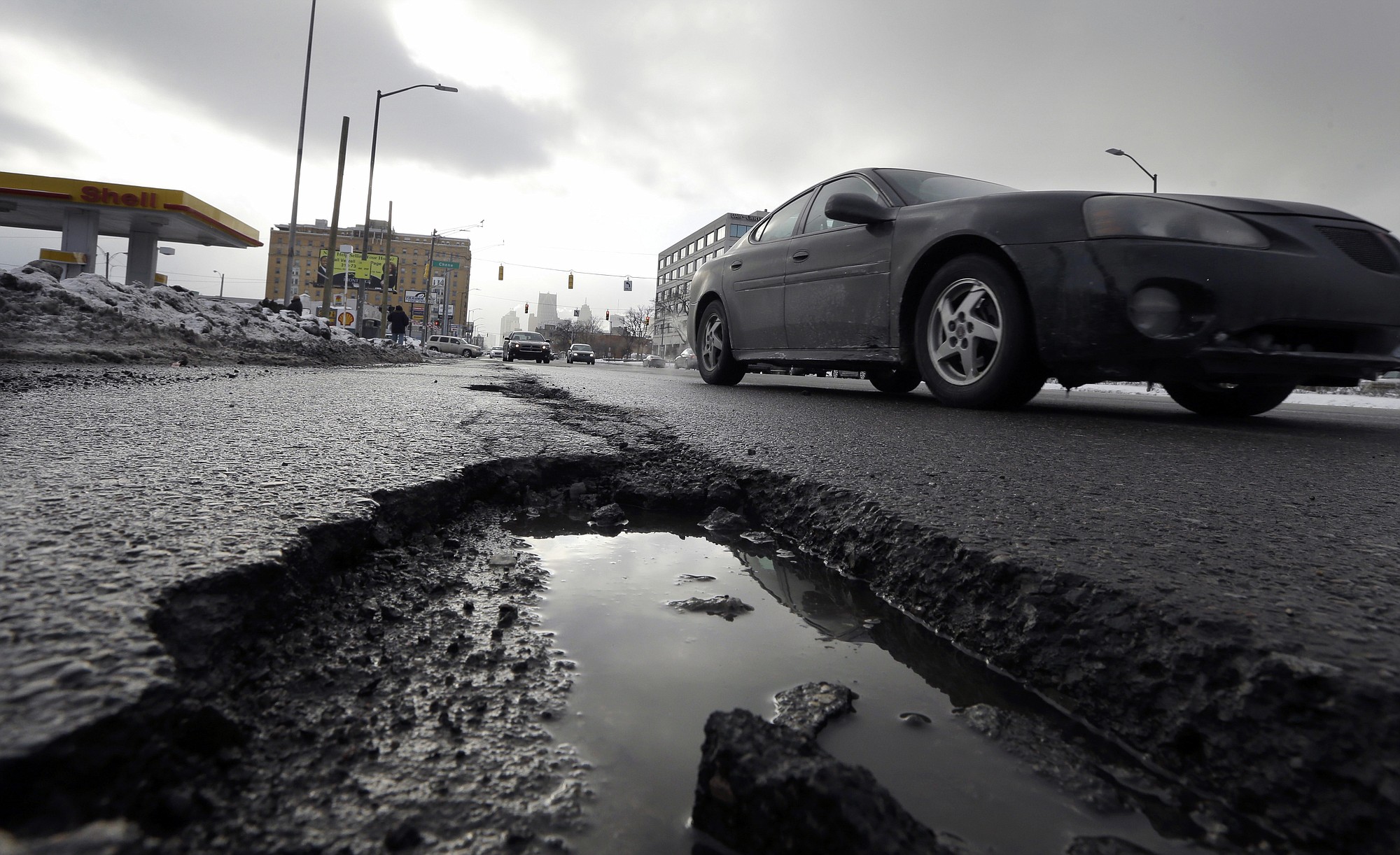 A car drives by a pothole in Detroit.