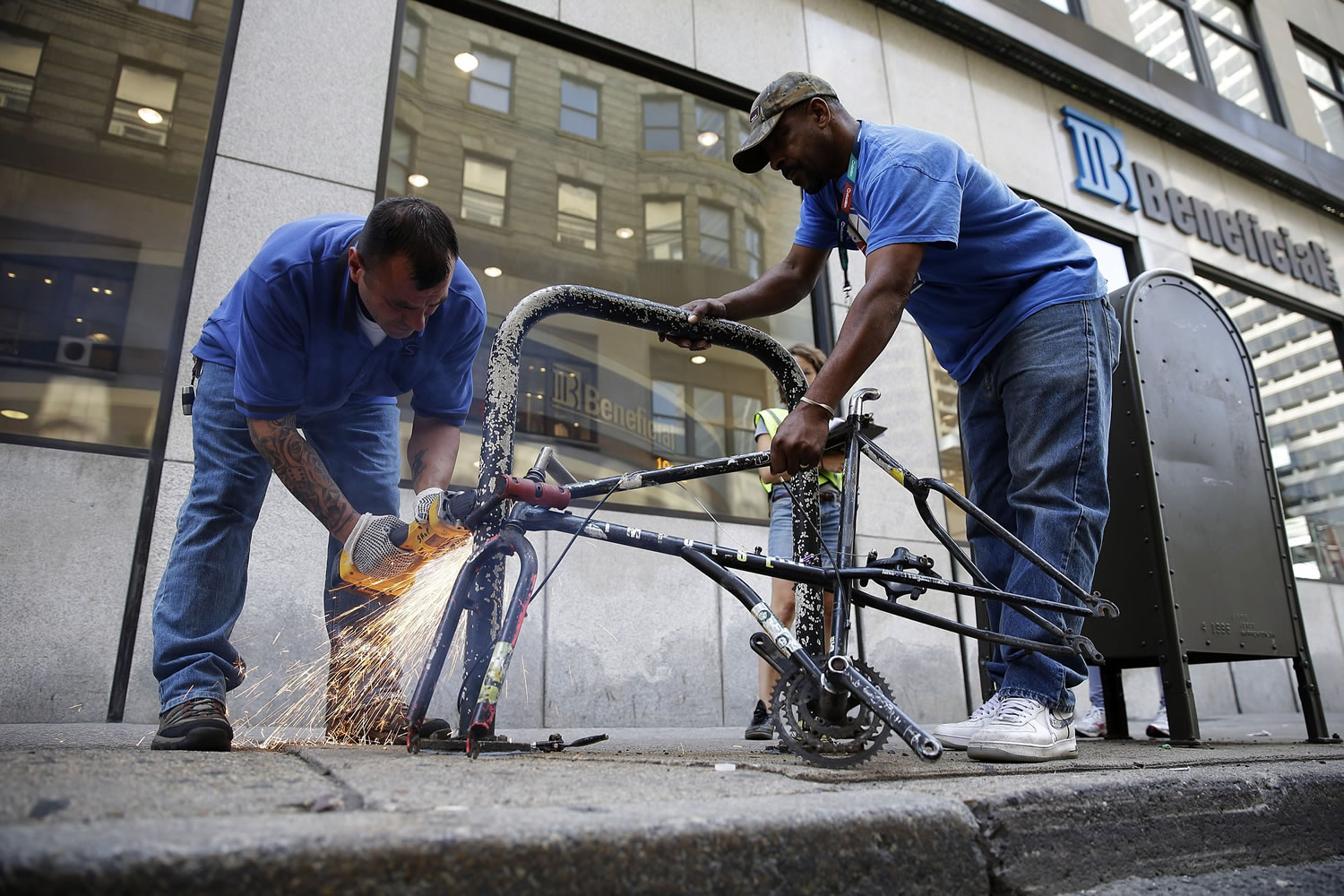 City workers remove an abandoned bike from a rack Thursday in Philadelphia.
