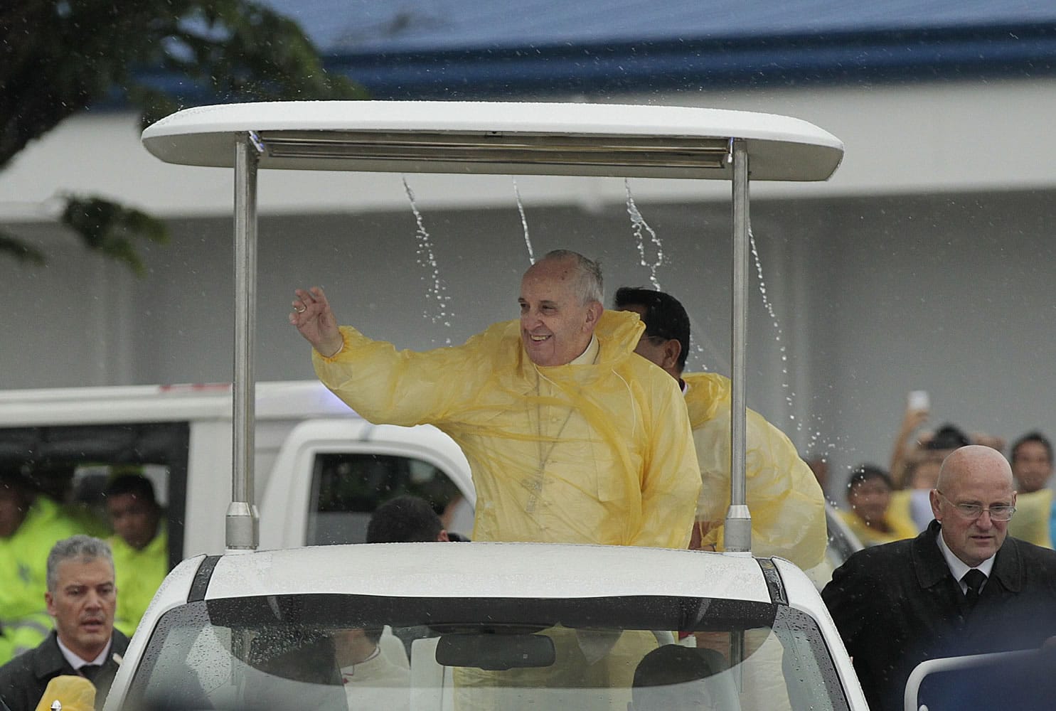 Pope Francis waves to the faithful on his arrival in Tacloban, Philippines, as rain drips from the roof of his vehicle.