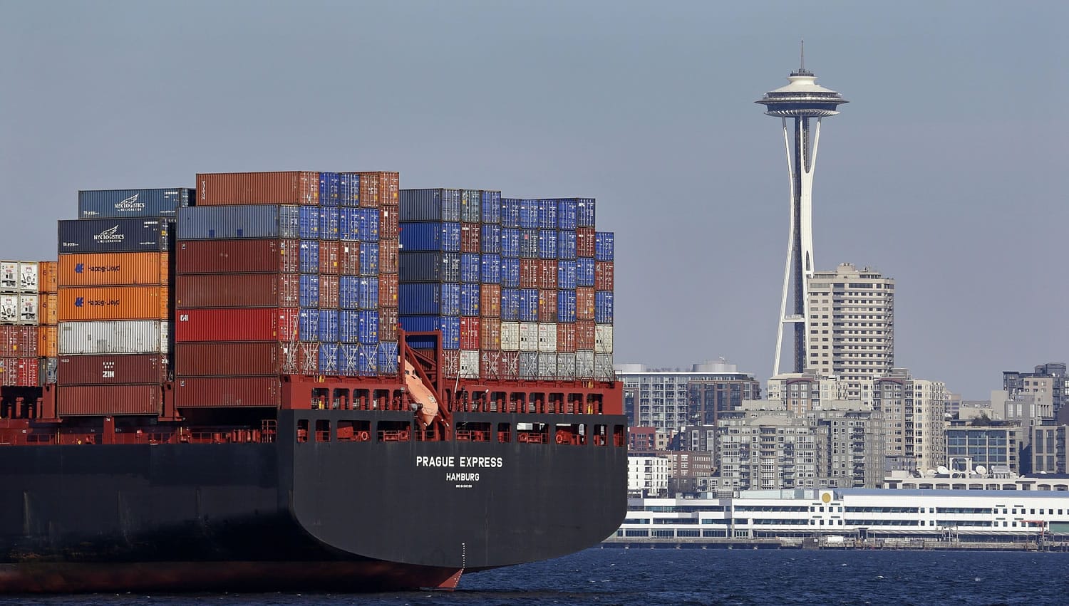 The Space Needle is seen just beyond a container ship anchored in Elliott Bay near downtown Sunday  in Seattle.
