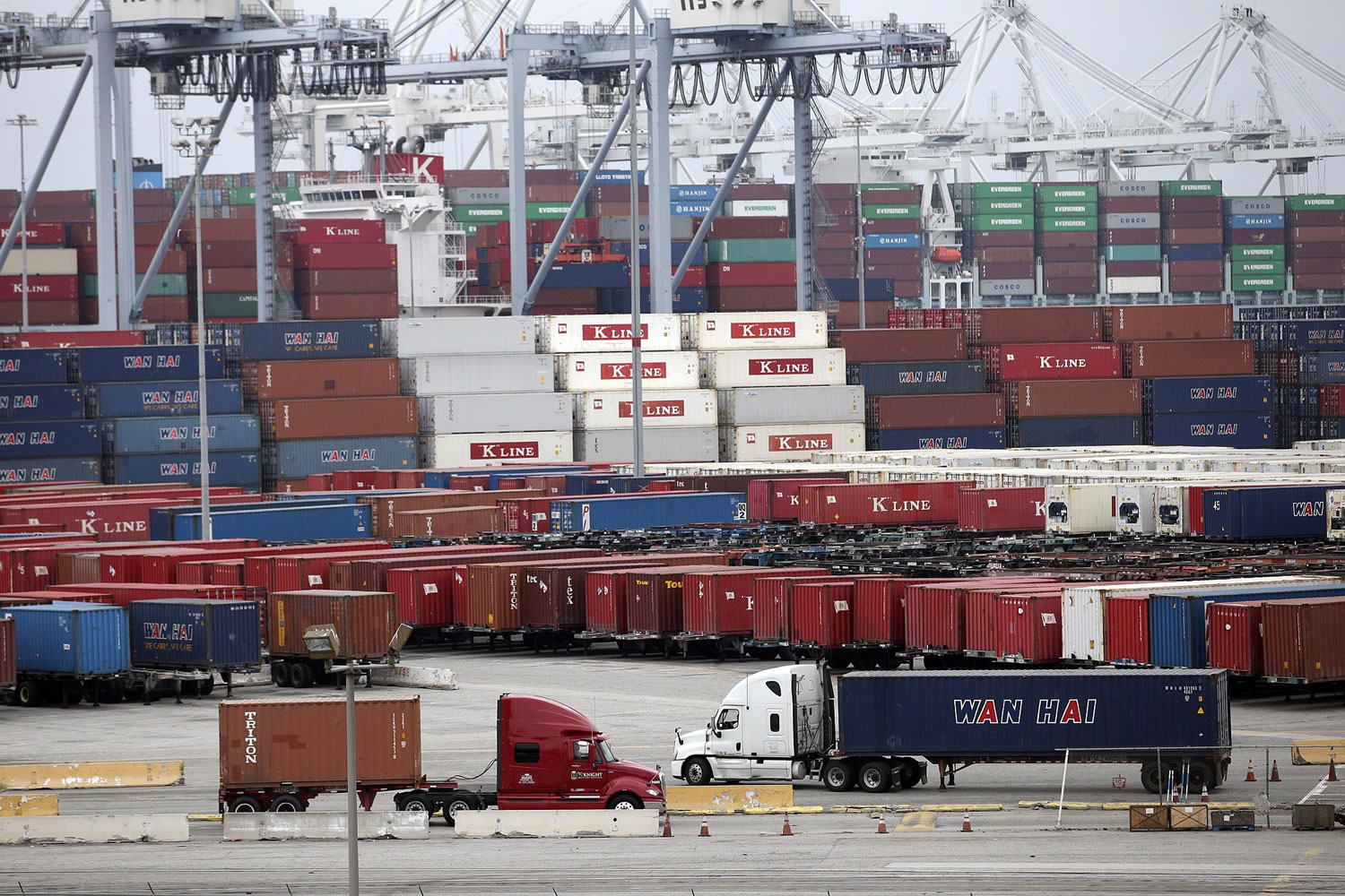 Two trucks move shipping containers at the Port of Long Beachon  Tuesday in Long Beach, Calif.