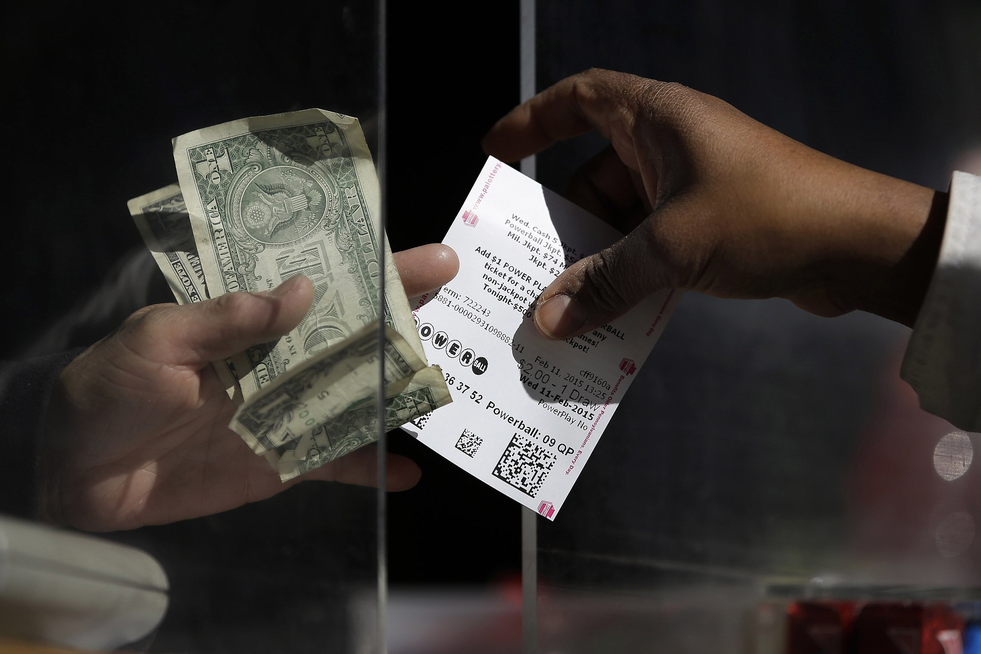 A woman buys a Powerball ticket at a newsstand, Wednesday in Philadelphia. The Powerball jackpot has climbed to $500 million, making Wednesday night's drawing the fifth largest prize in U.S.