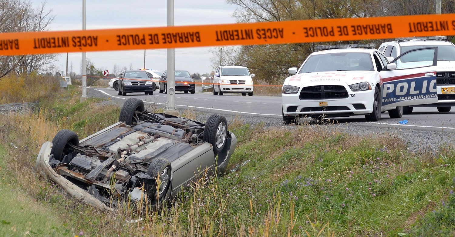 A car is overturned in the ditch in a cordoned off area in St-Jean-sur-Richelieu, Quebec, on Monday.