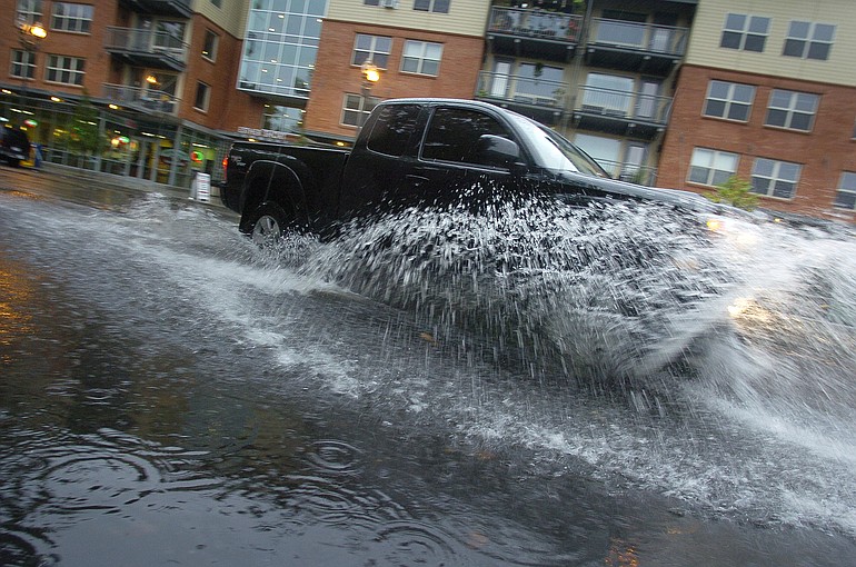 A truck drives through a puddle on 8th Street in downtown Vancouver.