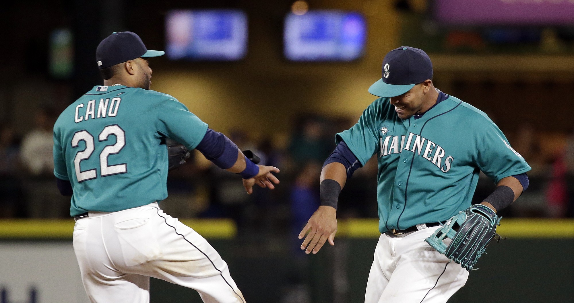 Seattle Mariners Robinson Cano (22) and Nelson Cruz share congratulations after the Mariners defeated the Texas Rangers 4-3 in a baseball game Friday, Aug. 7, 2015, in Seattle.