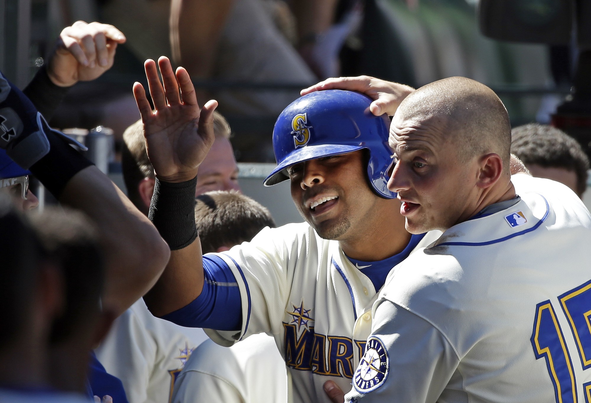 Seattle Mariners' Nelson Cruz, center, is congratulated after his home run by Kyle Seager (15) and teammates against the Texas Rangers in the sixth inning Sunday, Aug. 9, 2015, in Seattle. The Mariners won 4-2.