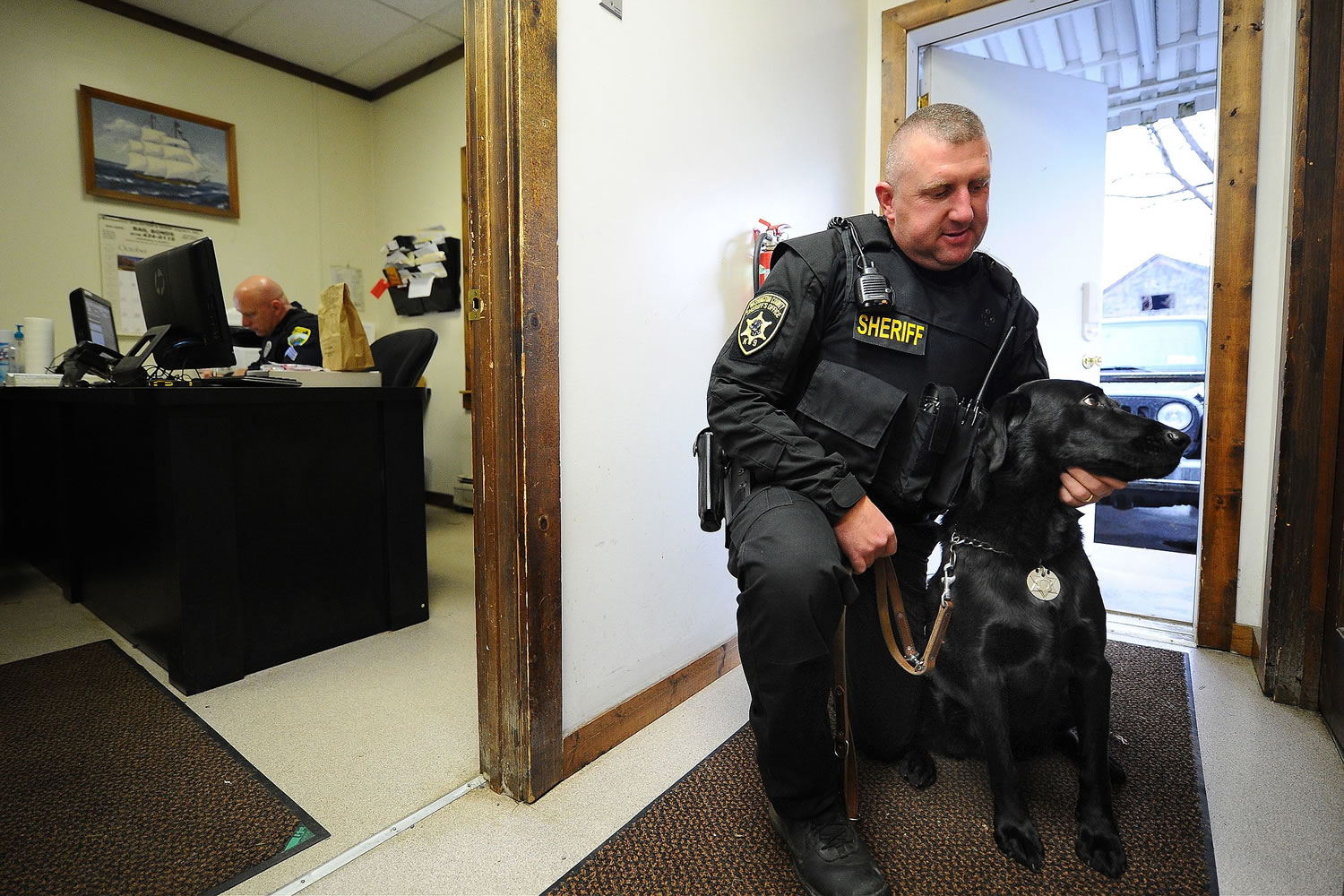 Fort Edward police officer Scott Stark holds police dog Nass on Wednesday in Fort Edward, N.Y.