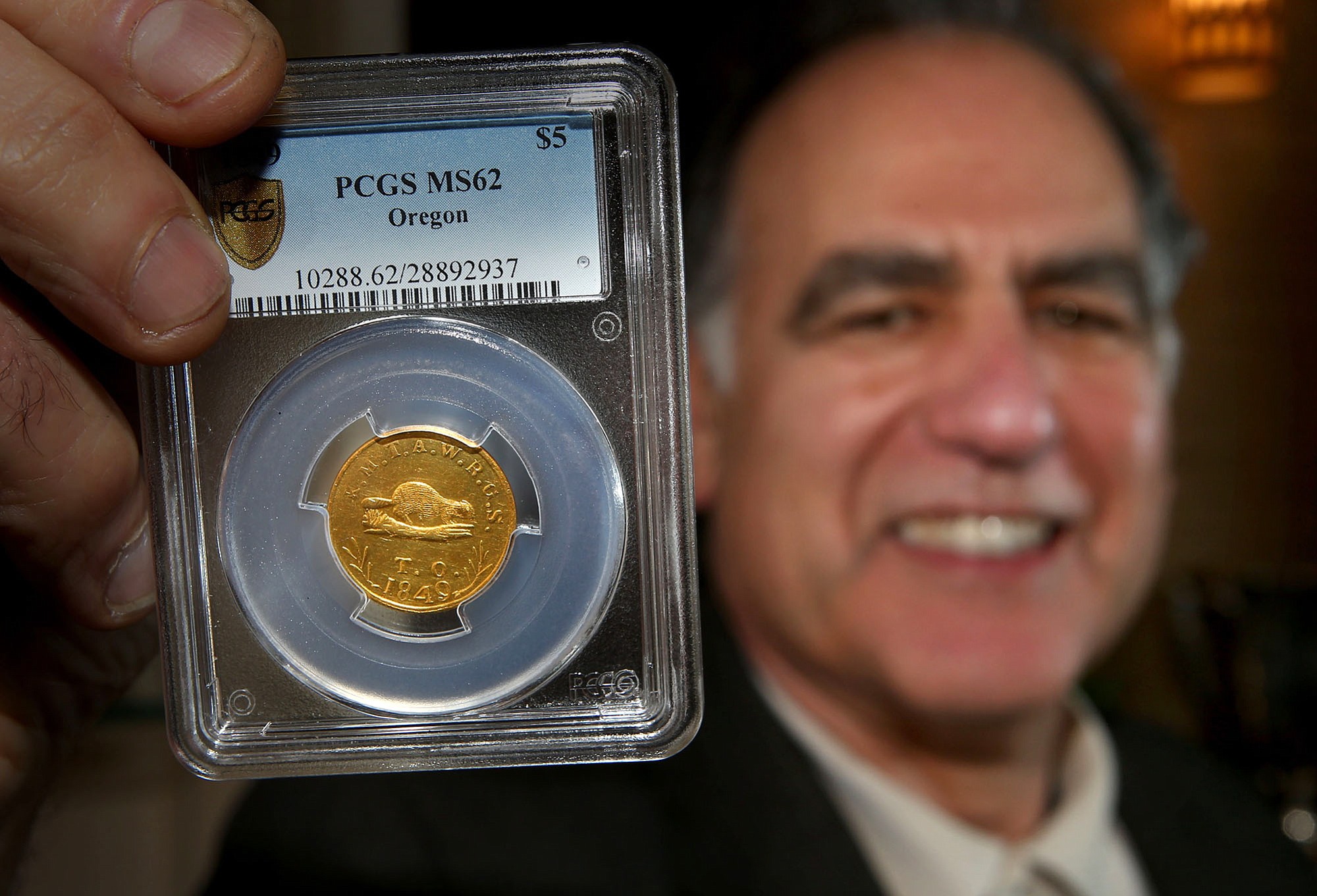 Collector David Nelkin displays a rare gold coin Tuesday that was made in Oregon City in 1849 at his coin store in Eugene, Ore.