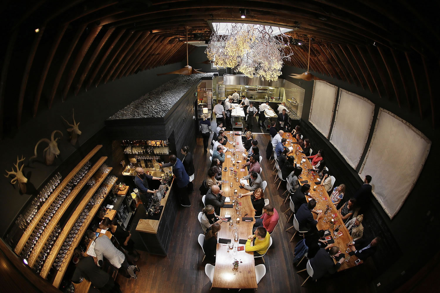 Communal tables are filled with ticketed diners for the first seating at the Lazy Bear restaurant in San Francisco. Lazy Bear uses an increasingly popular ticketing system model for its &quot;reservations&quot; that asks diners to pay up front for their meals much the way theater patrons pay for their seats.
