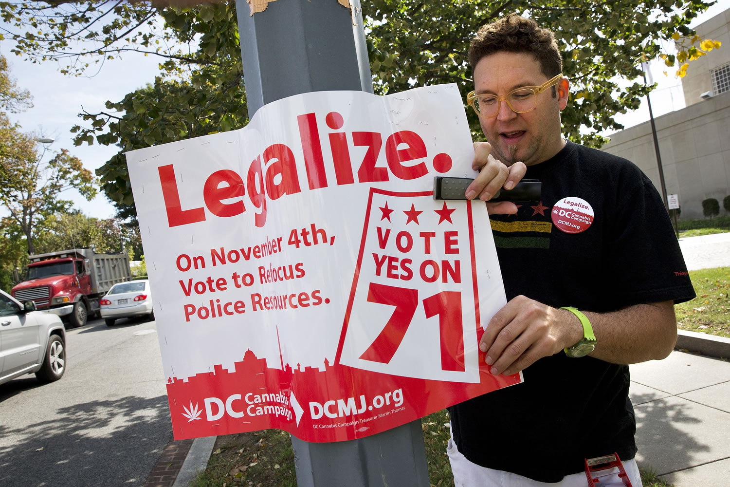 Adam Eidinger, chairman of the DC Cannabis Campaign, puts up posters encouraging people to vote yes on DC Ballot Initiative 71 to legalize small amounts of marijuana for personal use in Washington.