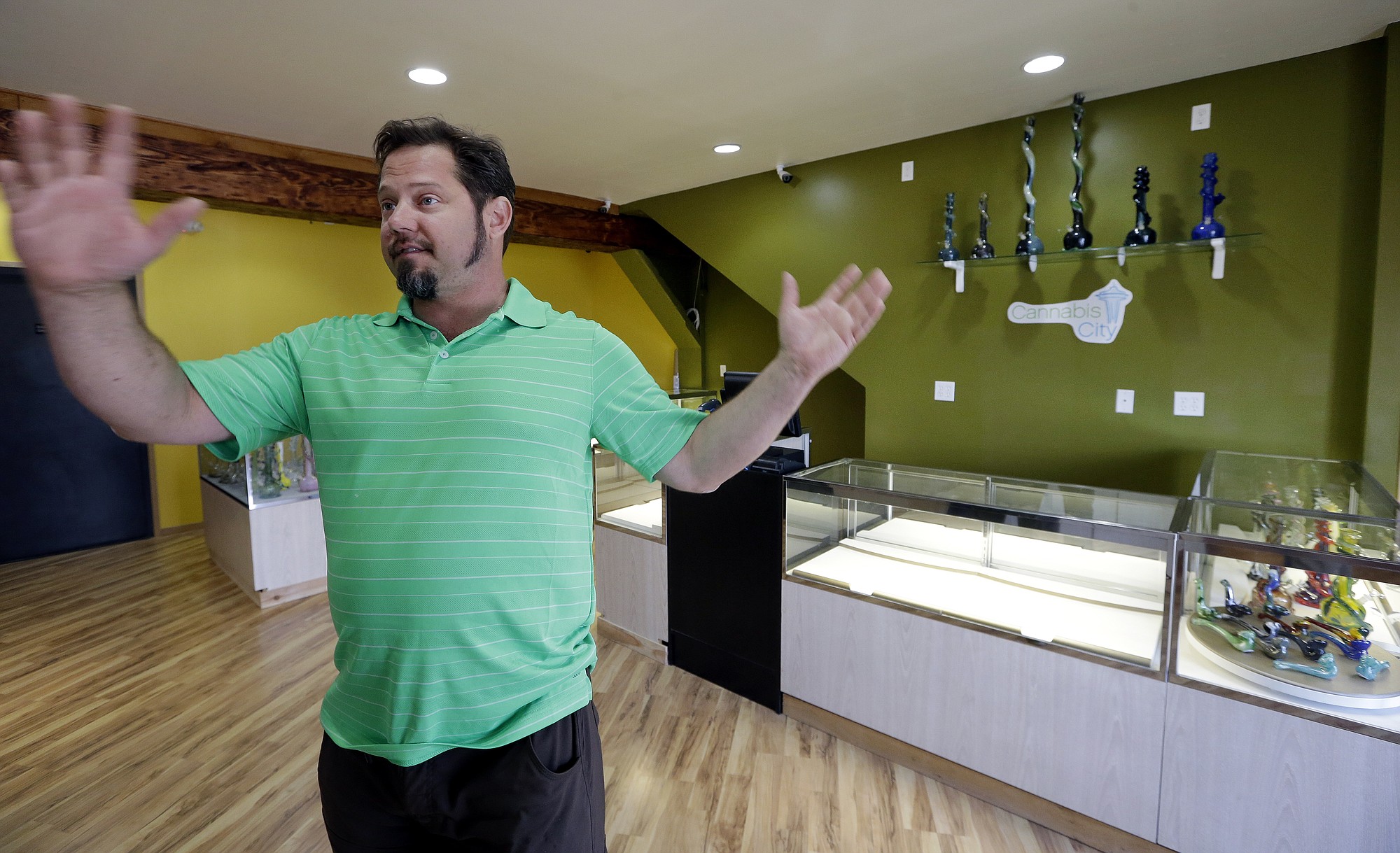 Cannabis City owner James Lathrop gestures as he stands in the middle of his new marijuana shop days before the grand opening Wednesday in Seattle.