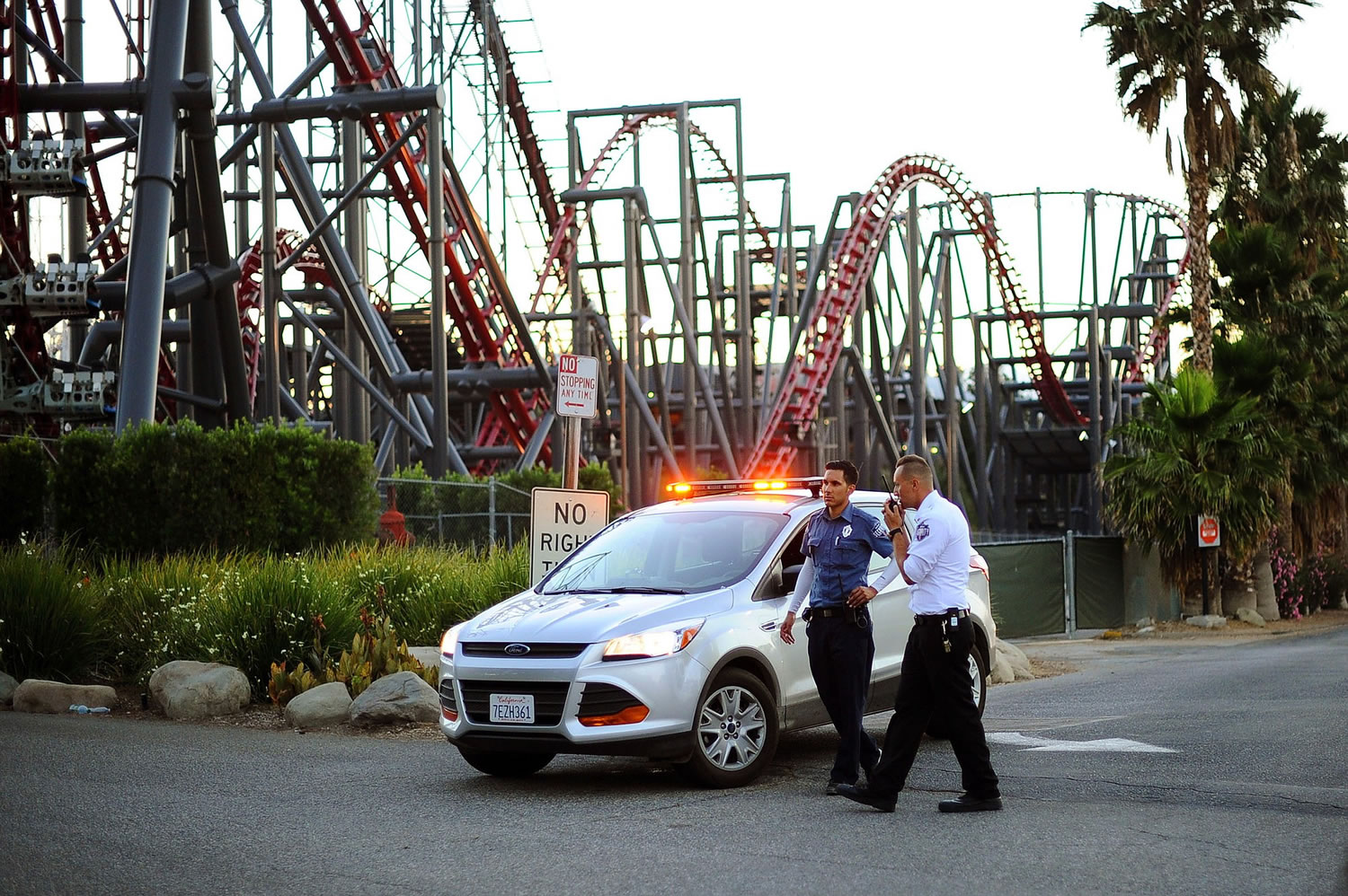 Members of the Six Flags Magic Mountain amusement park security staff monitor the situation at the exit of the park after riders were injured on the Ninja coaster Monday in Valencia, Calif.