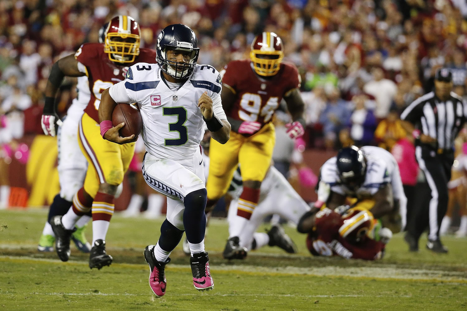 Seattle Seahawks quarterback Russell Wilson (3) scrambles with the ball during the second half of an NFL football game against the Washington Redskins in Landover, Md.
