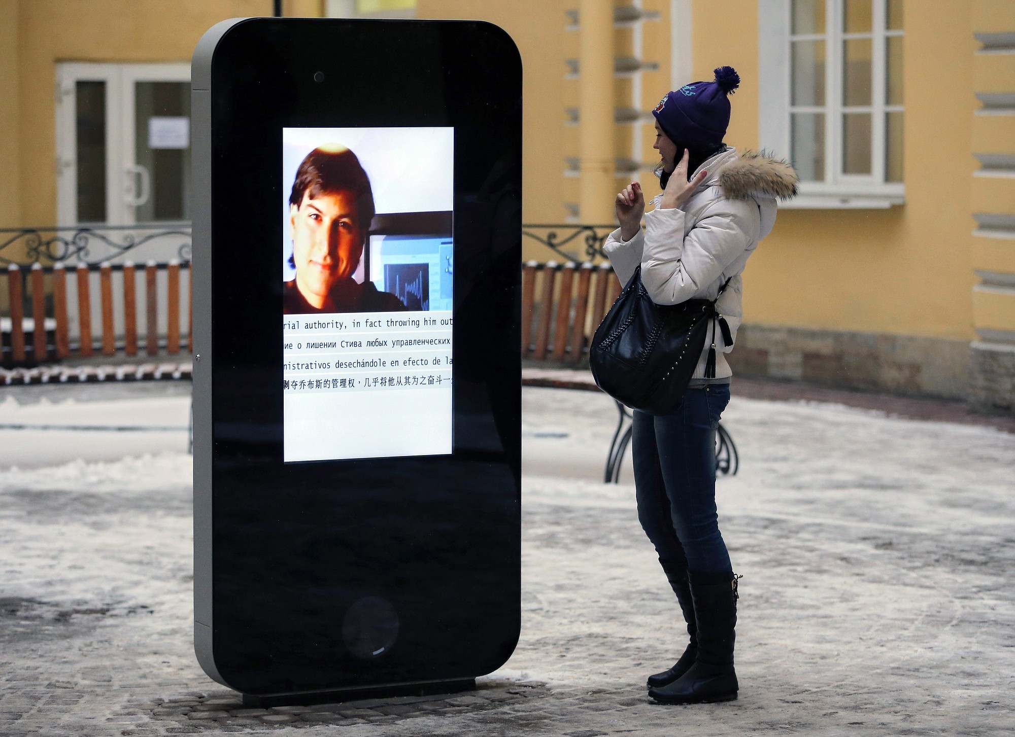A woman stands next to a screen last year showing a portrait of Steve Jobs on the memorial to the late Apple Corp. co-founder in the courtyard of the Techno Park of the St. Petersburg National Research University of Information Technologies, Mechanics and Optics  in St.