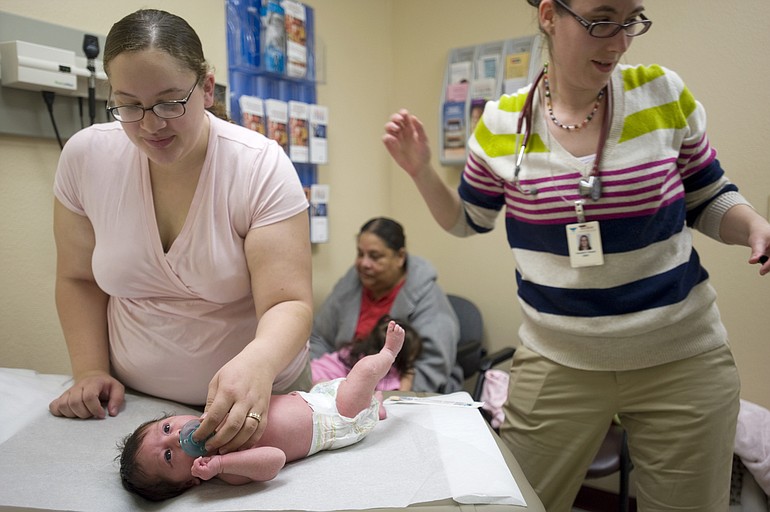 Kimberly Cervantes, left, comforts her newborn baby girl, Jessenya, two-weeks-old, while Amanda Roesch, ARNP, right, gives her a &quot;well child check-up&quot; at the Sea Mar Community Health Center on Delaware Lane on February 8.