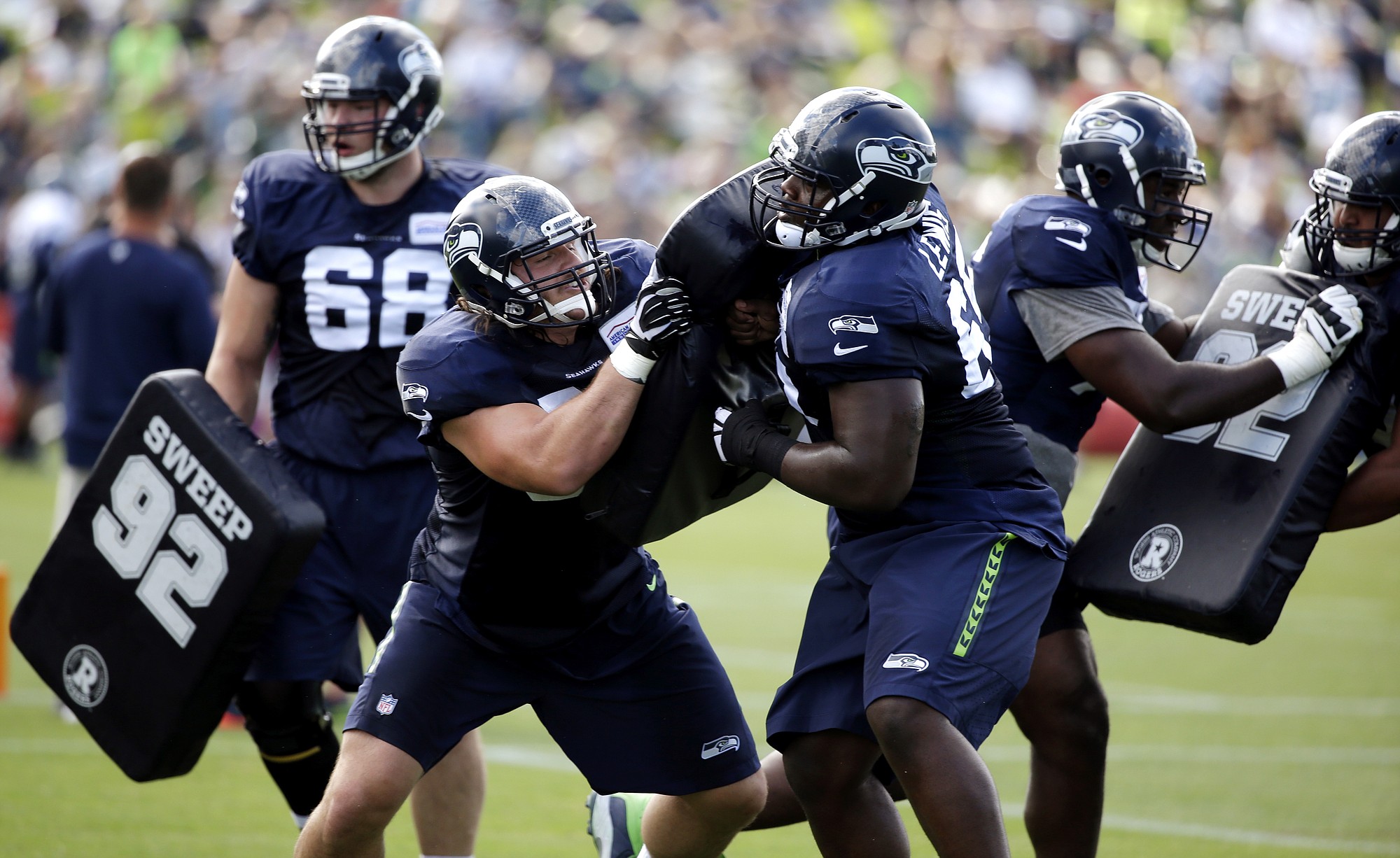Seattle Seahawks Kristjan Sokoli, second left, and Patrick Lewis push against each other in a drill at a training camp.