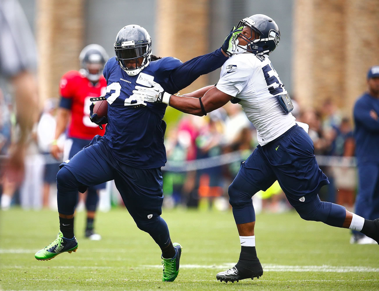 Seattle Times photo
Seattle Seahawks running back Marshawn Lynch, left, lays a stiff arm on linebacker Marcus Dowtin during training camp Tuesday  in Renton. After talking to the running back, the Seahawks said the assault allegations against Lynch are without merit.