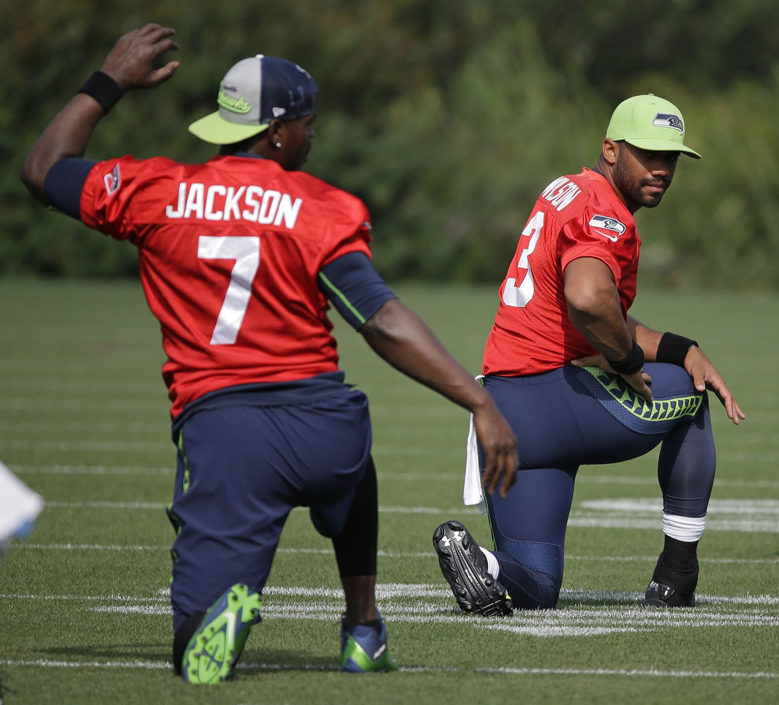 Seattle Seahawks quarterback Russell Wilson, right, and backup quarterback Tavaris Jackson, left, stretch Thursday, Aug. 13, 2015, during training camp in Renton. The Seahawks will play the Denver Broncos Friday in a preseason game in Seattle. (AP Photo/Ted S.