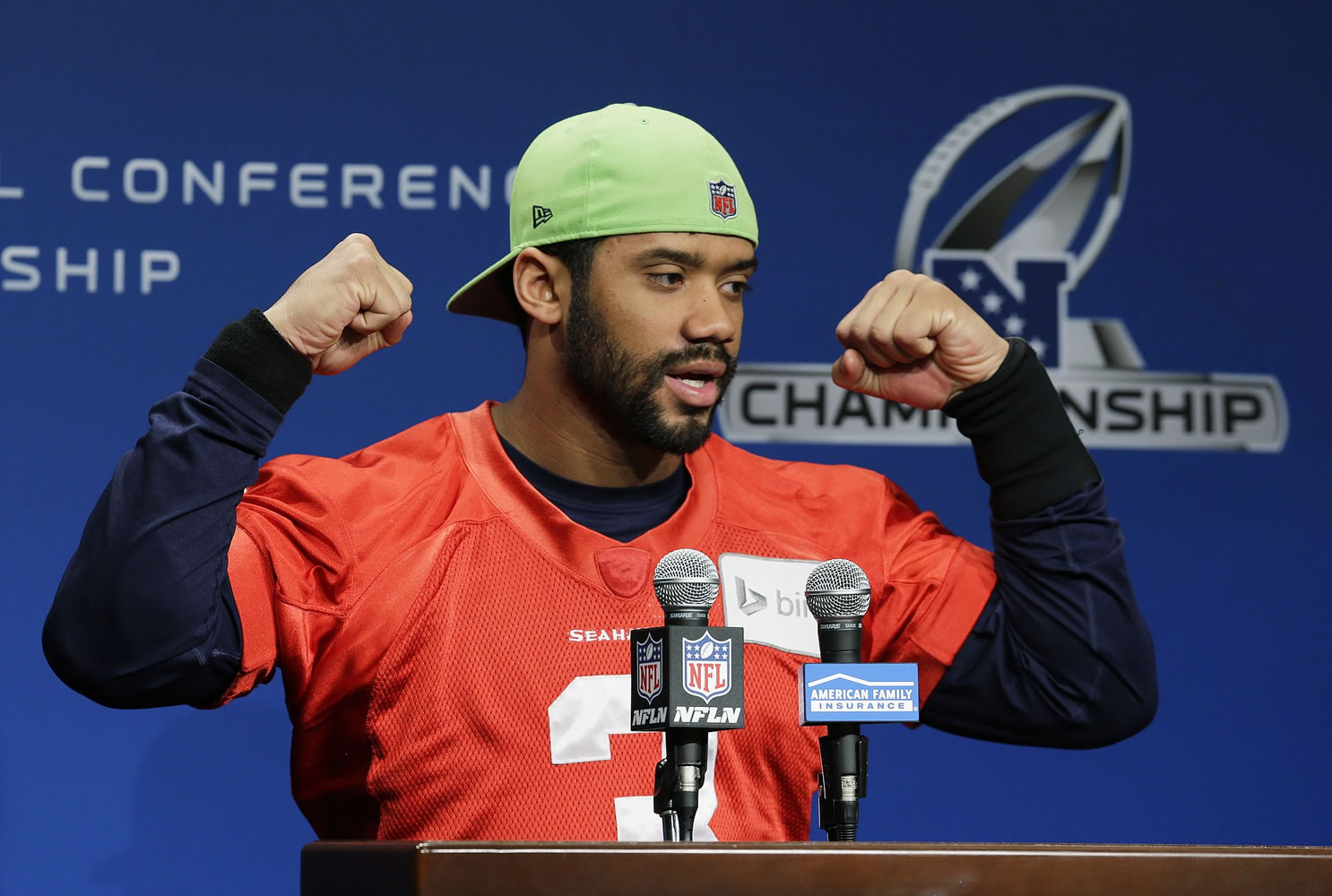 Seattle Seahawks quarterback Russell Wilson raises his arms and ends his remarks to reporters with his traditional &quot;Go Hawks!,&quot; Wednesday before practice in Renton. The Seahawks will face the Green Bay Packers, Sunday in the NFC Championship game. (AP Photo/Ted S.