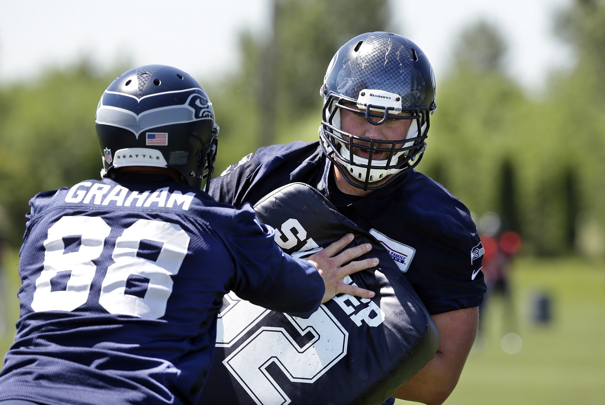 Seattle Seahawks' Jesse Davis, right, runs through a drill with Jimmy Graham (88) during an NFL football organized team activity on Tuesday, June 9, 2015, in Renton.