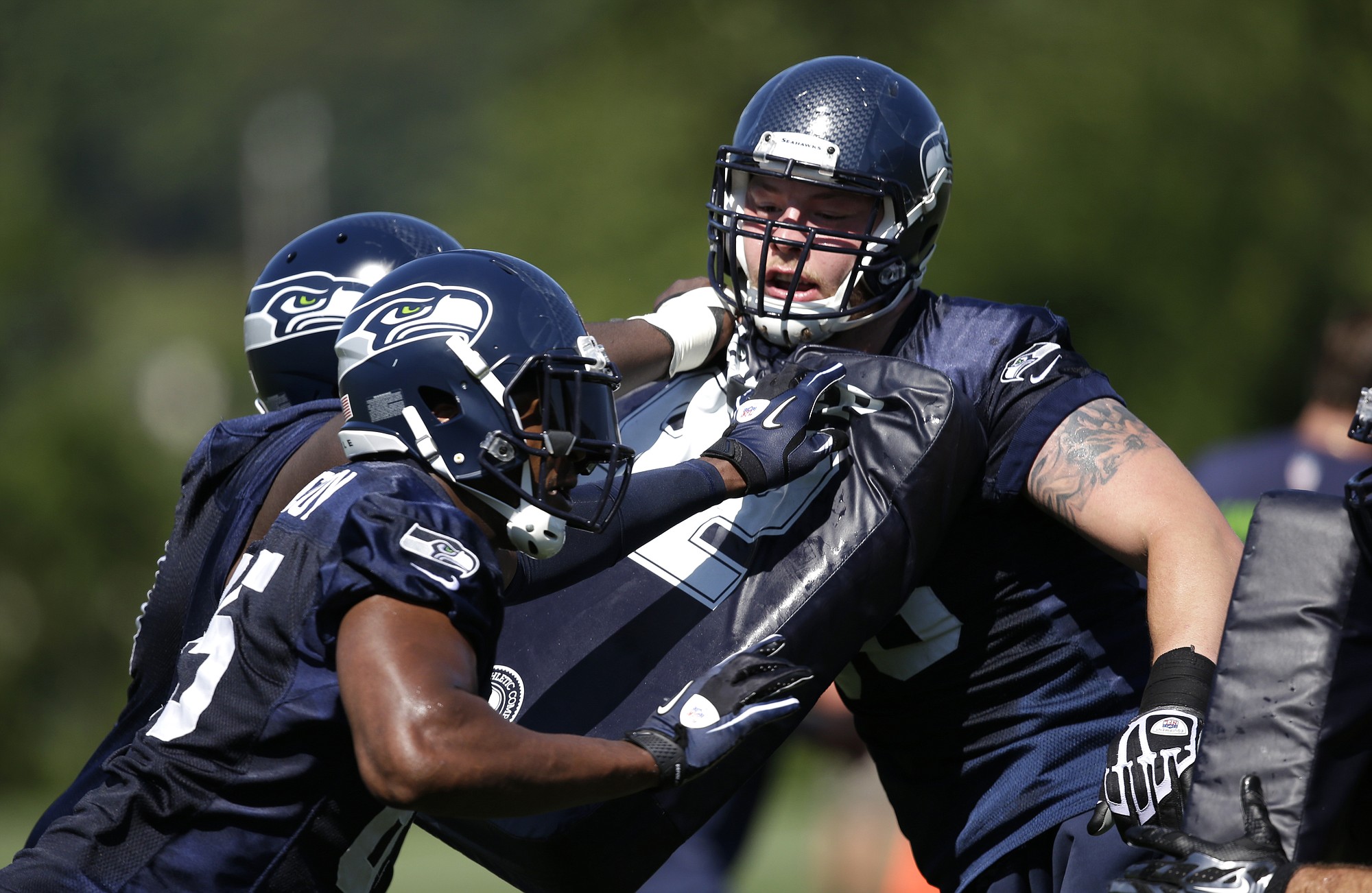 Seattle Seahawks' Justin Britt, right, is pushed back during a drill at training camp practice on Saturday, July 26, 2014, in Renton.