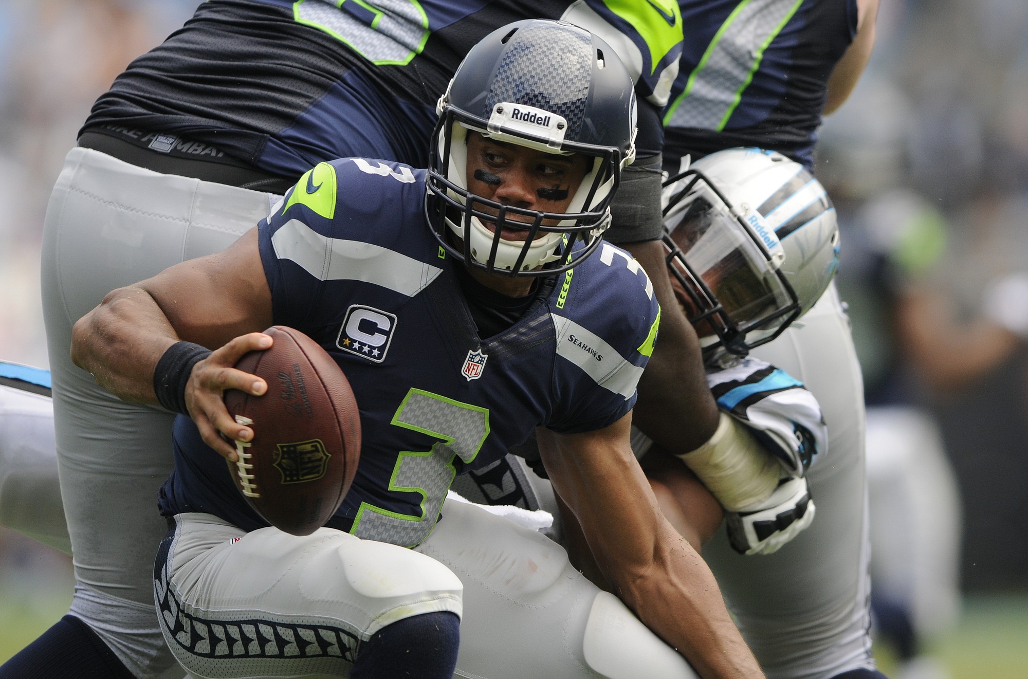 Seattle Seahawks quarterback Russell Wilson (3) scrambles away from a Carolina Panthers player during the second half of an NFL football game in Charlotte, N.C., Sunday, Sept. 8, 2013.