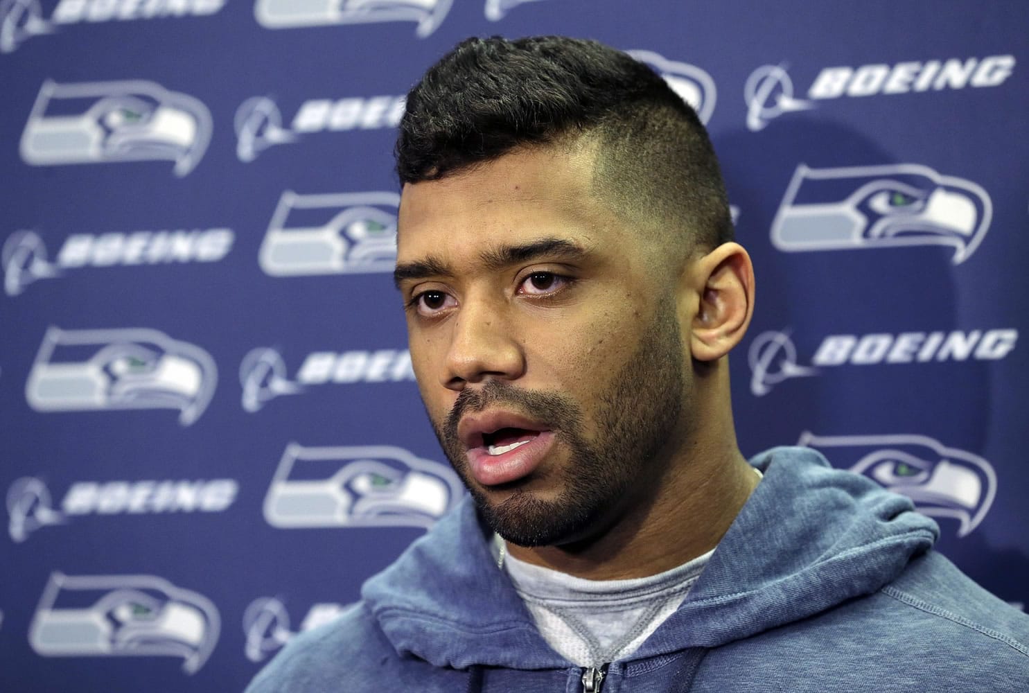 Seattle Seahawks quarterback Russell Wilson talks to reporters outside the locker room at team headquarters, Tuesday, Feb. 3, 2015, in Renton. Signing the QB to a new contract is one of issues the team needs to address in the offseason. (AP Photo/Ted S.
