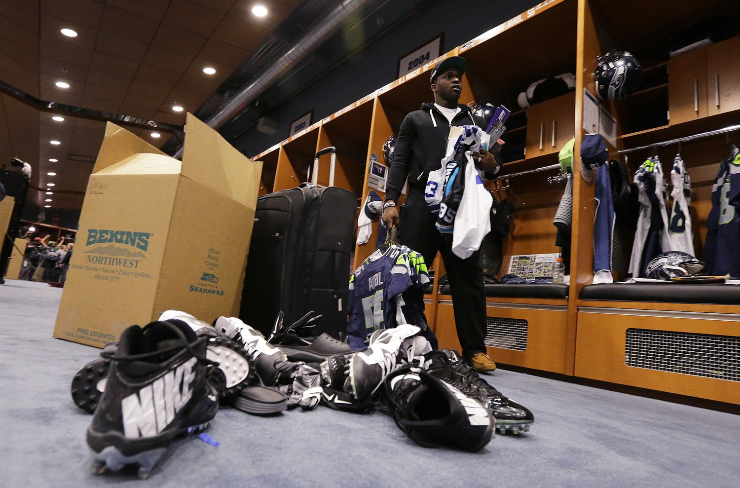 Seattle Seahawks defensive end Cliff Avril packs up football cleats and other items in front of his his space in the team locker room, Tuesday, Feb. 3, 2015, in Renton. (AP Photo/Ted S.