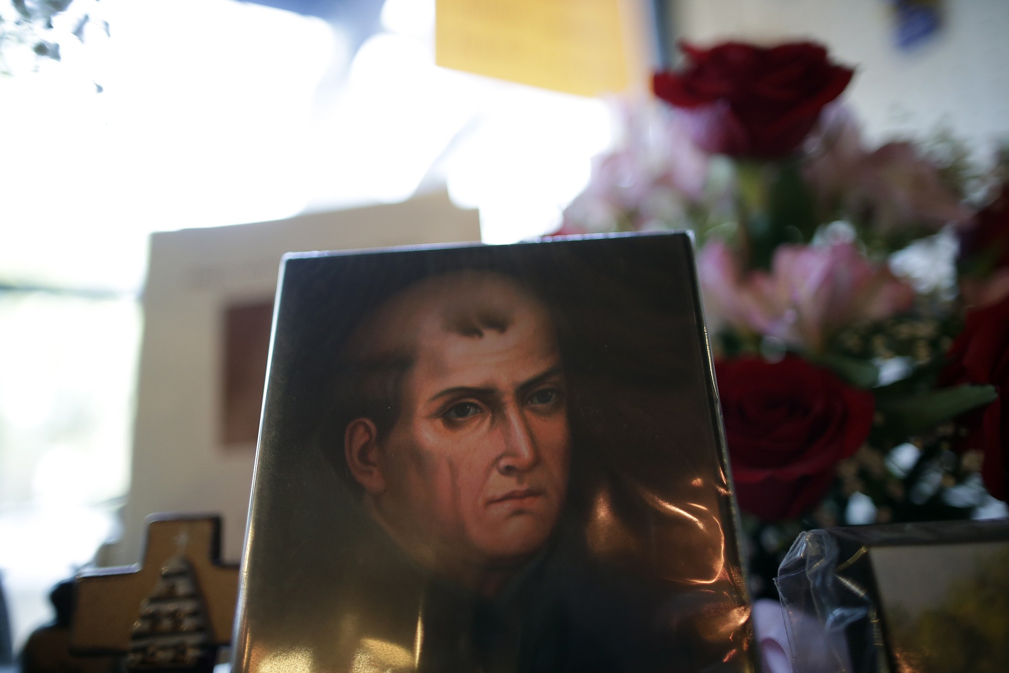 In this Jan. 27, 2015 image, a portrait of Franciscan missionary Junipero Serra can be seen in the gift shop of the Mission San Diego de Acala in San Diego. Pope Francis' announcement that he will canonize Serra is meeting resistance by some in California and beyond, as critics say he wiped out native populations, enslaved converts and spread disease.