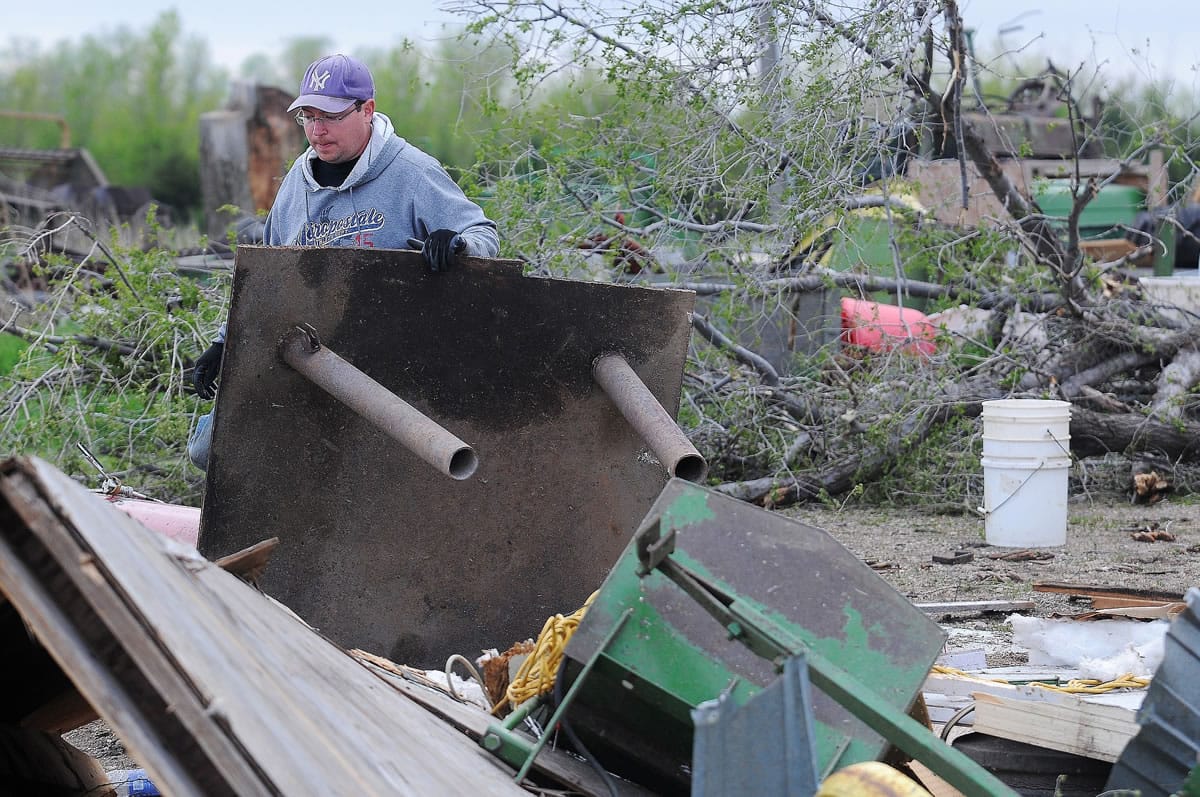 James Fink surveys the damage to family friend Mike Fechner's farm on Sunday near Delmont, S.D., after a tornado tore through the area damaging homes and businesses on Sunday morning.