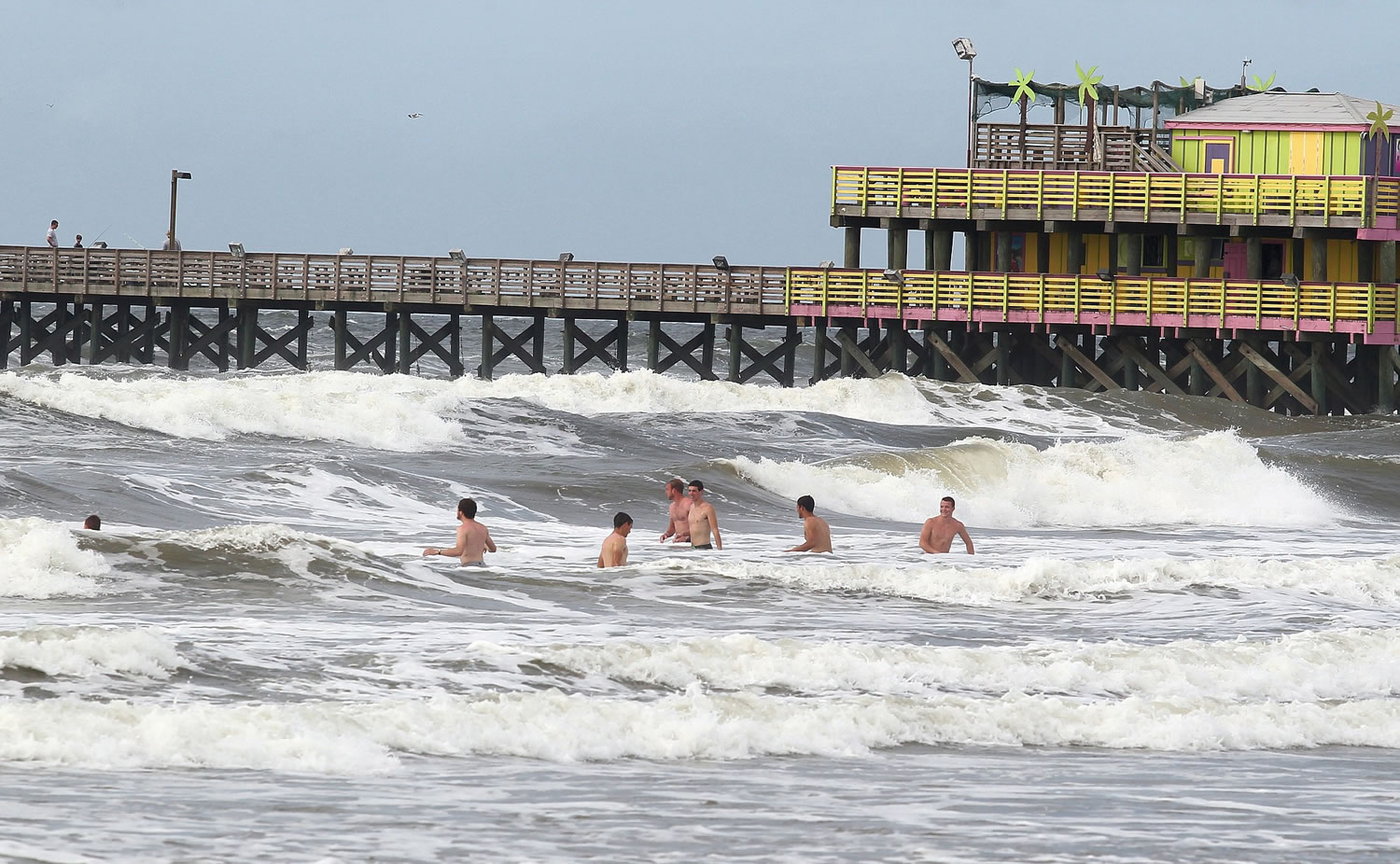 Rough surf doesn't deter swimmers near the 61st Street Pier in Galveston, Texas, on Monday.