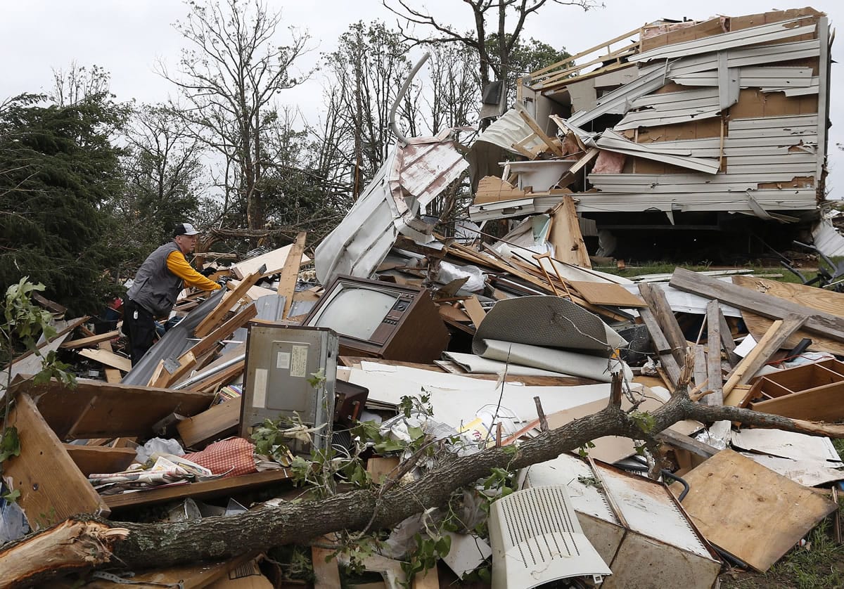 Lee Hoyle, of Chickasaw Nation search and rescue, digs through the debris of a mobile home in the Steelman Estates Mobile Home Park, destroyed by Sunday's tornado, near Shawnee, Okla., on Monday.