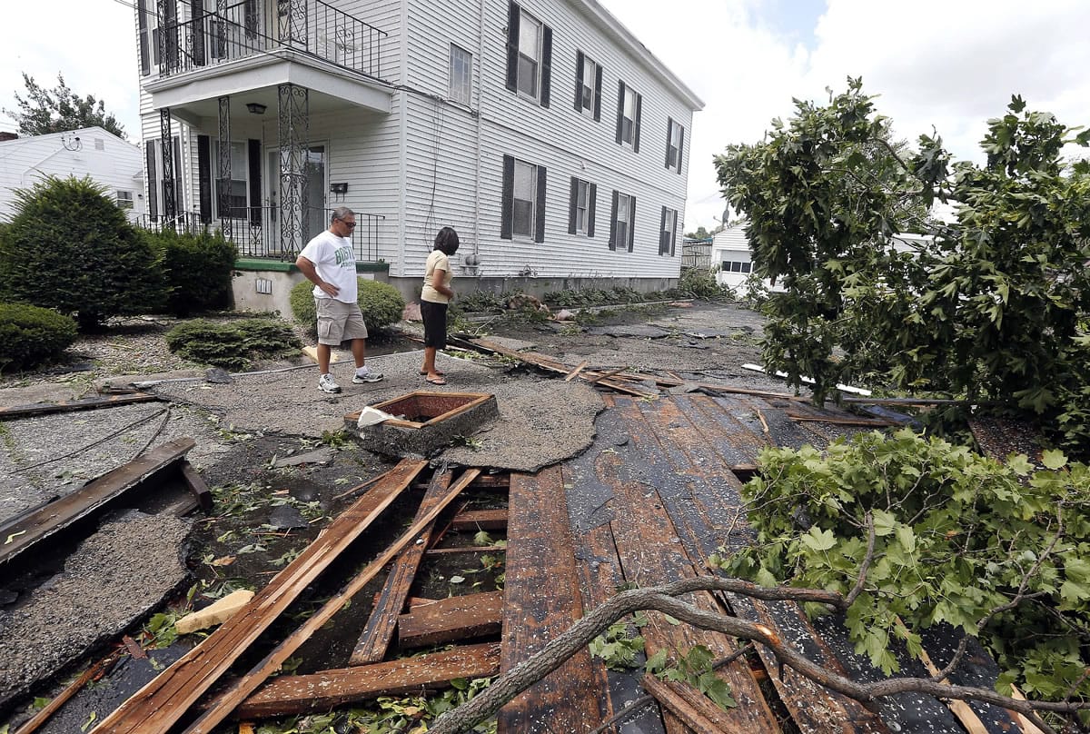 Christine Molle and her husband, Wayne, survey the damage to her mother's house in Revere, Mass., on Monday after a tornado touched down.