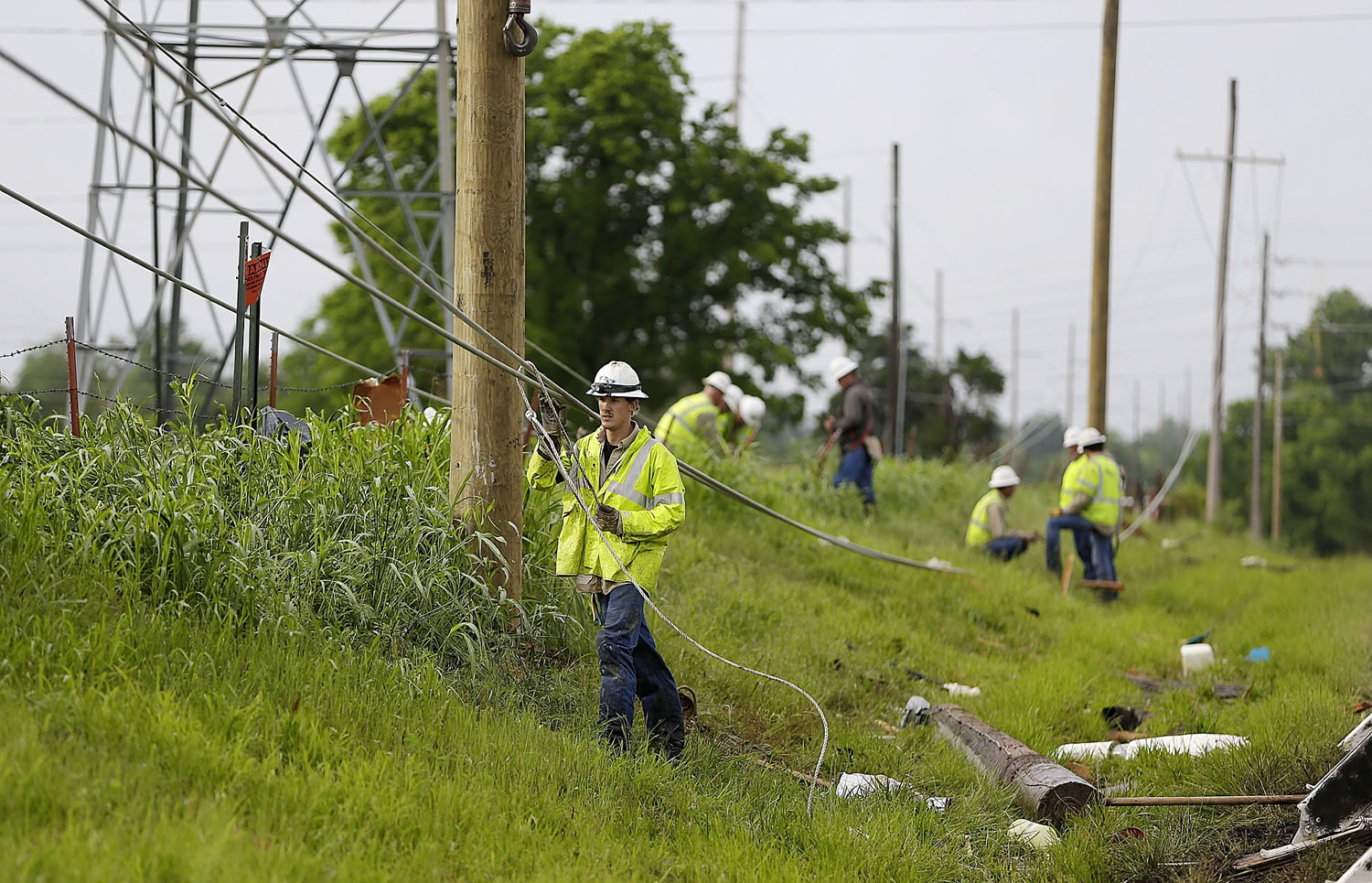 Utility crews work on downed lines Sunday after a strong storm hit the area Saturday night and early Sunday morning, in Broken Arrow, Okla.
