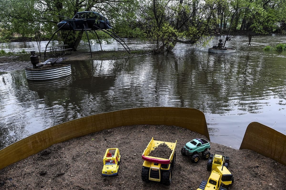 Figures in the Swetsville Zoo in Fort Collins, Colo., are surrounded by water Friday as levels along the Poudre River are high with more rain expected in the Fort Collins and Windsor area.