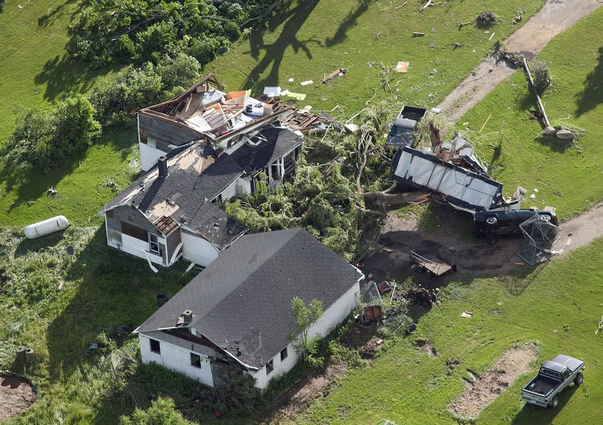 This aerial photo shows a damaged house and car Tuesday in southwest Tuscola County, Mich.