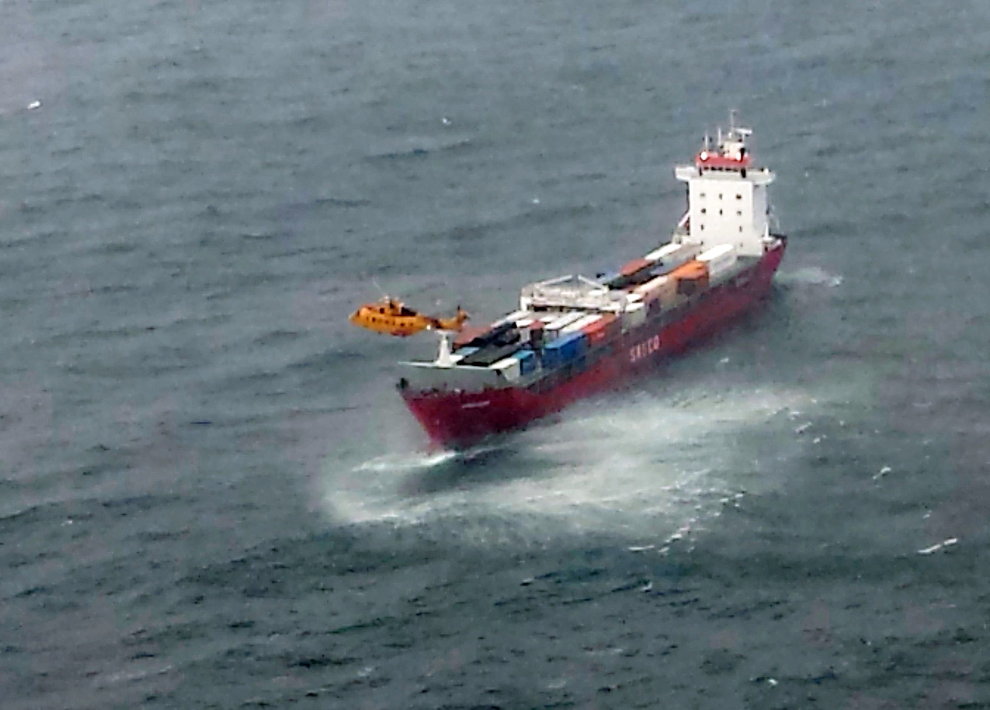 A Canadian Coast Guard helicopter flies near a Russian container ship, carrying hundreds of tons of fuel drifting without power in rough seas off British Columbia's northern coast on Friday.