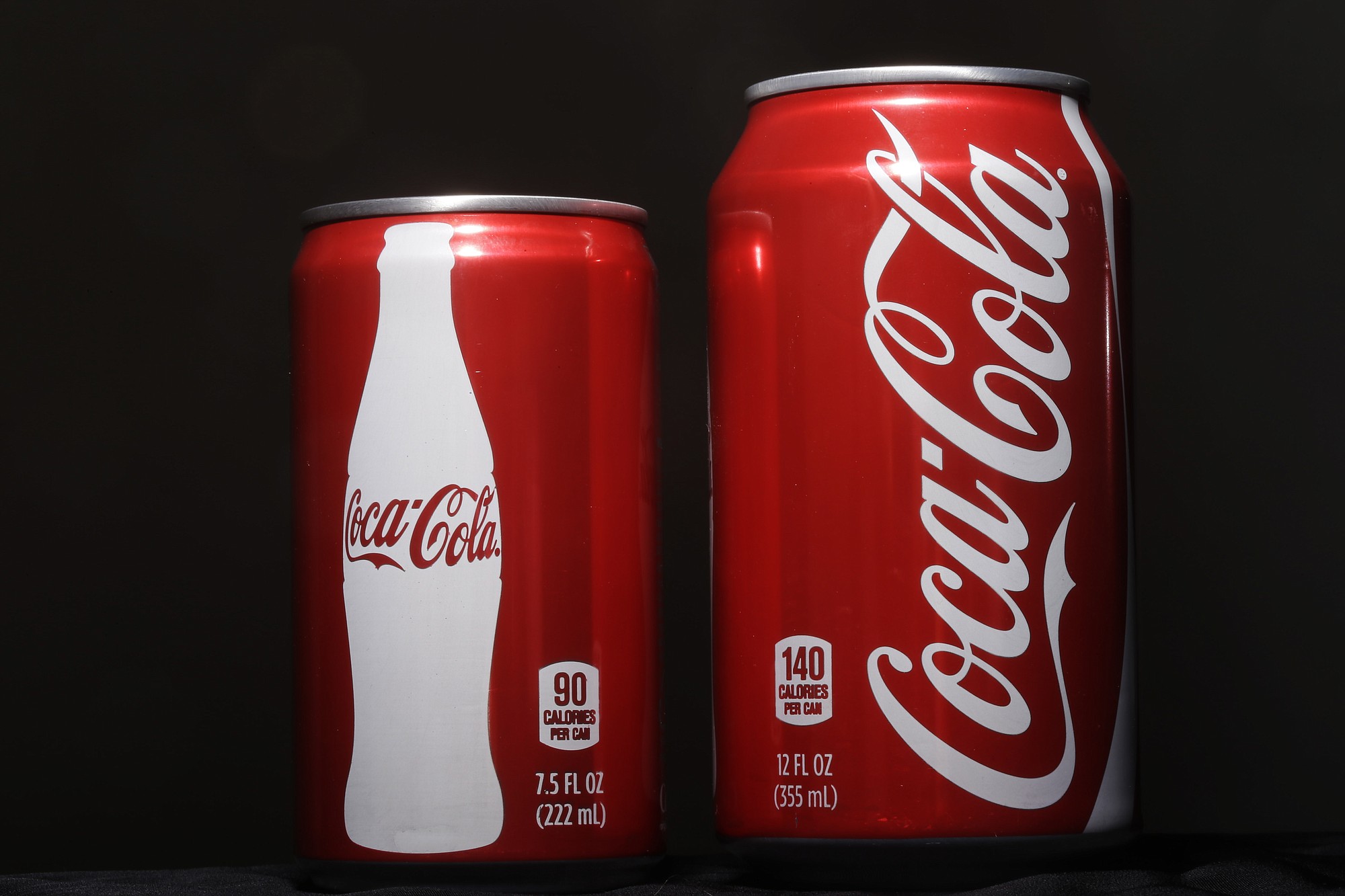 A 7.5-ounce can of Coca-cola, left, is next to a 12-ounce can for comparison.