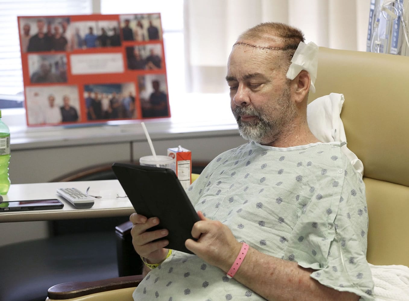James Boysen reads messages in his hospital bed Wednesday at Houston Methodist Hospital, in Houston.