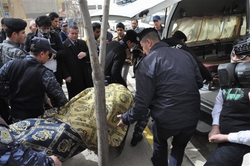 The body of slain American gym teacher Jeremiah Small is carried out of the school in Sulaimaniyah on Thursday.