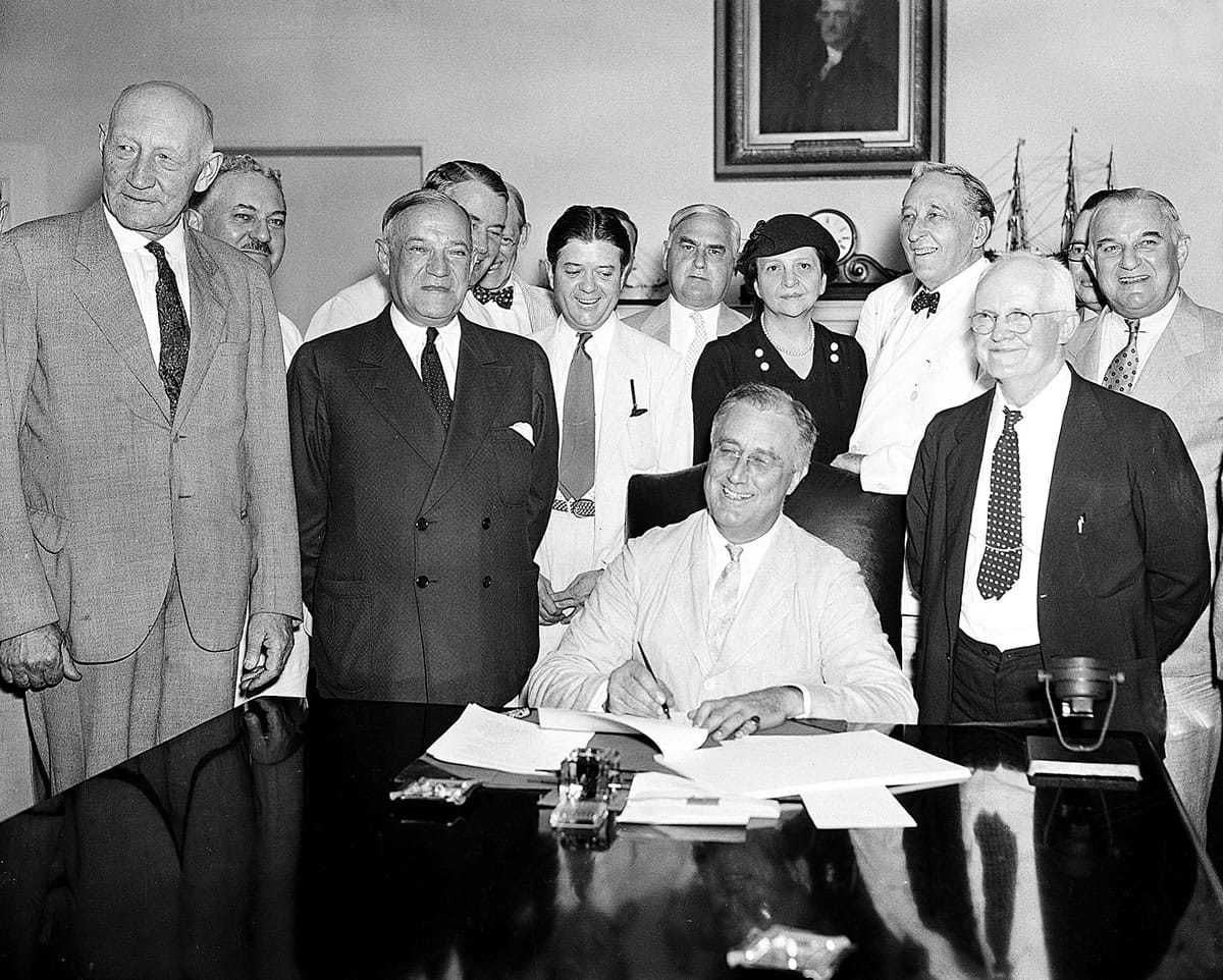President Franklin Roosevelt signs the Social Security Bill in Washington on Aug.