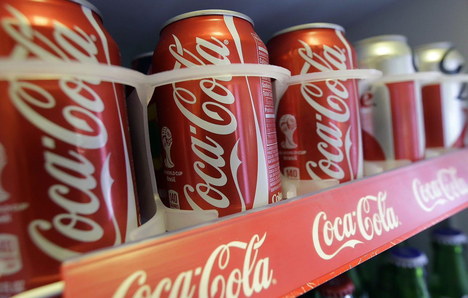 Cans of Coca-Cola soda pop are shown in the refrigerator inside of Chile Lindo in San Francisco. San Francisco and Berkeley are aiming to become the first U.S.