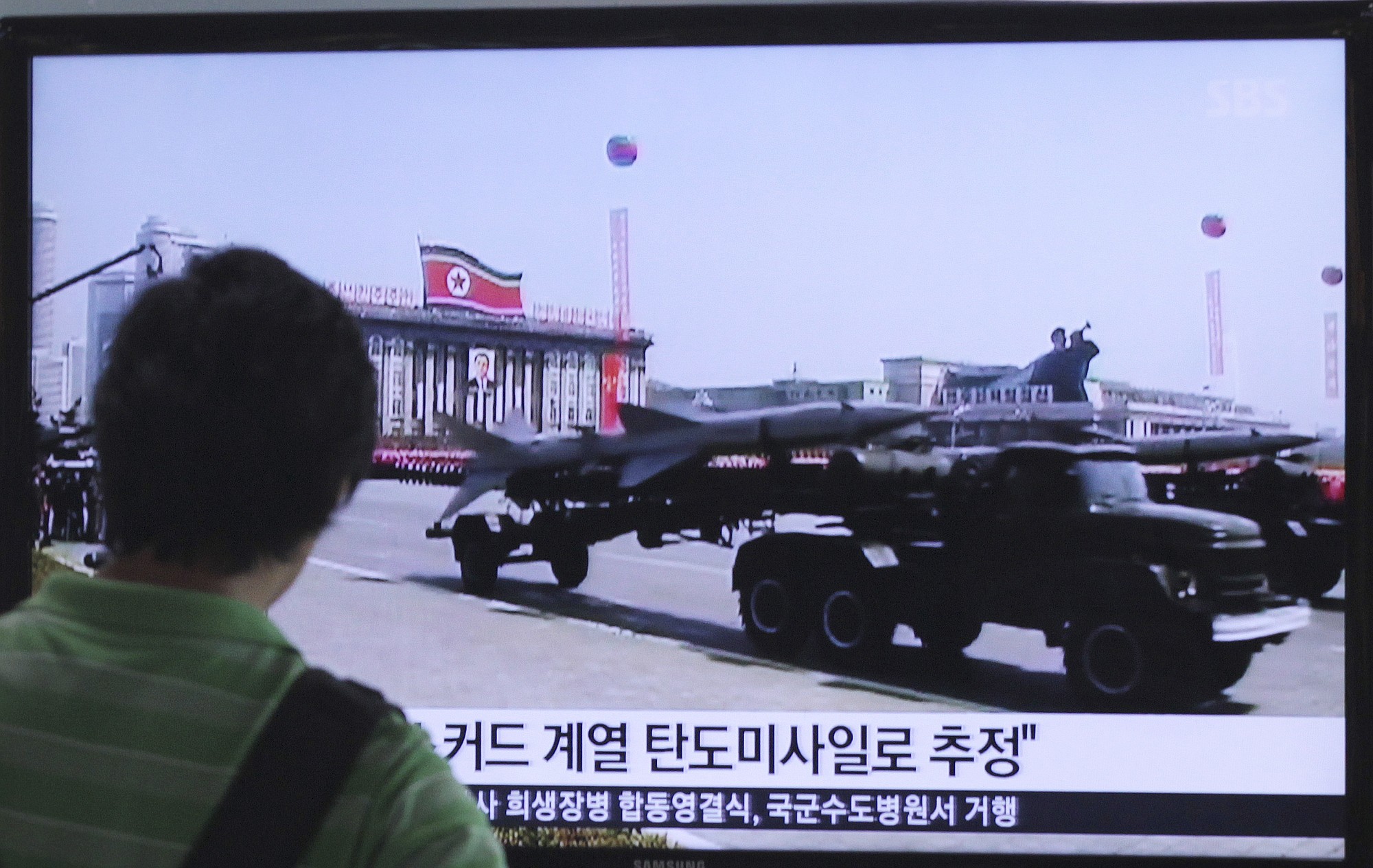 A man watches a TV news program Sunday showing file footage of a North Korean rocket carried during a military parade at Seoul Railway Station in Seoul, South Korea. North Korea fired two short-range missiles into its eastern waters Sunday, a South Korean official said, an apparent test fire that comes just days after the country tested what it called new precision-guided missiles.
