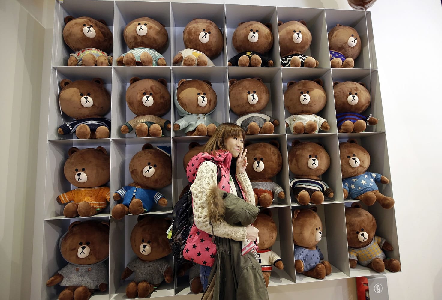 A tourist from Hong Kong poses for her souvenir photo in front of a display of Line's character Brown bear at the Line Friends flagship shop in Seoul, South Korea.