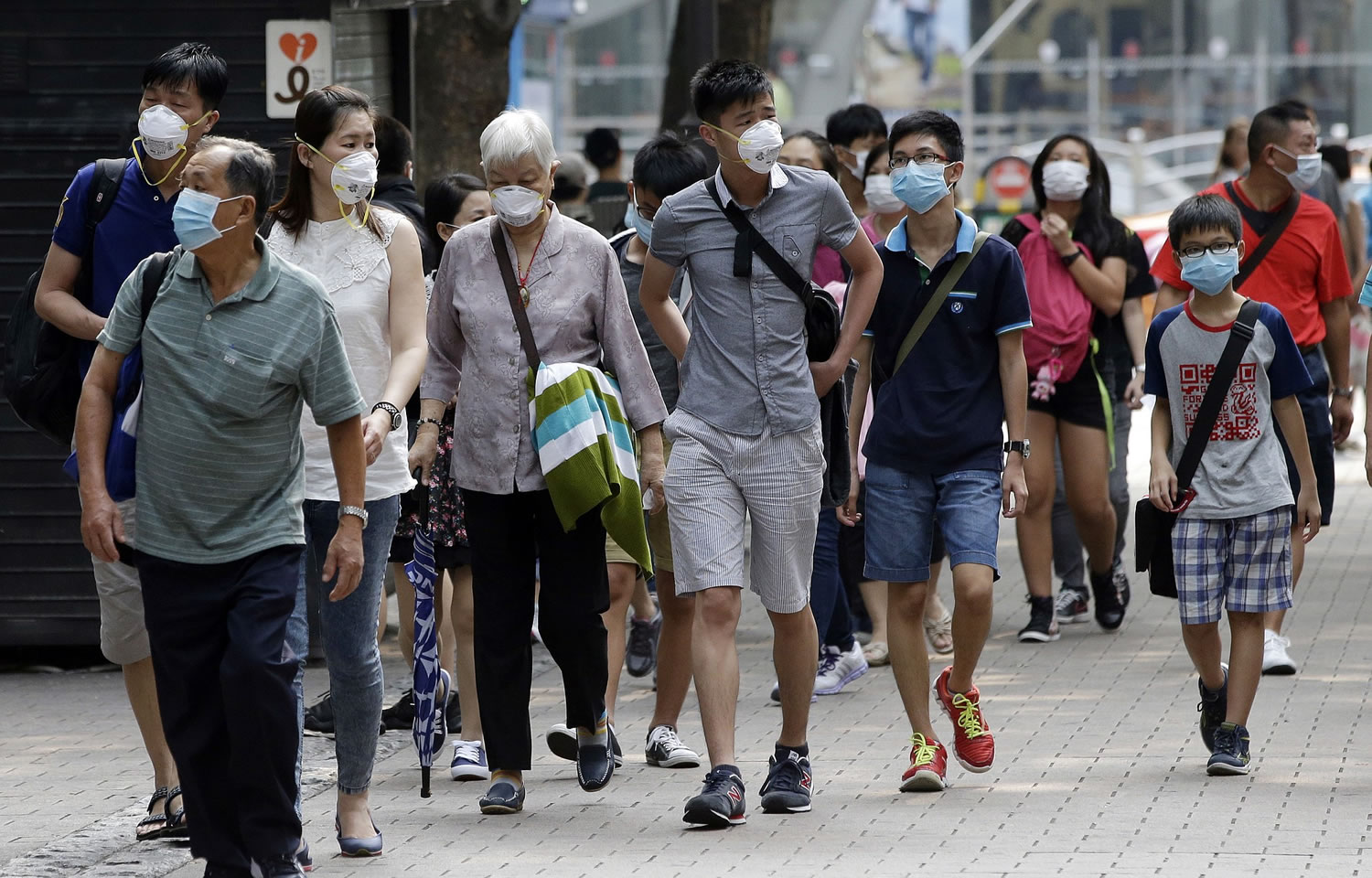 Visitors wearing masks as a precaution against the MERS (Middle East Respiratory Syndrome) virus walk at a shopping district in Seoul, South Korea, on Tuesday.